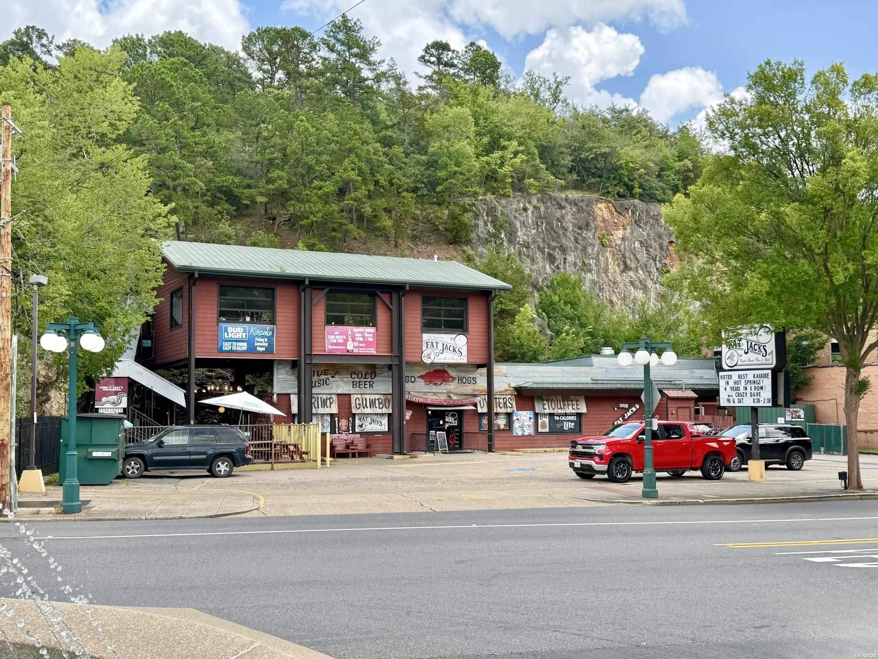 An exceptional opportunity to own a landmark commercial property in the heart of downtown Hot Springs. Currently home to the well-known Fat Jacks restaurant and bar, this premier property occupies a highly visible location on Central Avenue directly across from the former Majestic Hotel redevelopment site, surrounded by restaurants, shopping, entertainment and Hot Springs' most popular attractions. The building features spacious upper and lower levels, offering versatile commercial space suitable for a variety of future uses. Situated on approximately 0.40 acres with 150 feet of prime Central Avenue frontage, the property also includes a large private parking lot—an exceptionally rare and valuable amenity in downtown Hot Springs that provides a significant advantage for customers, tenants, and future redevelopment. Offering outstanding visibility, excellent accessibility, and one of the most sought-after commercial locations in the city, this is a rare opportunity to acquire a premier downtown investment property. Real estate only. Business operations are not included in the sale.