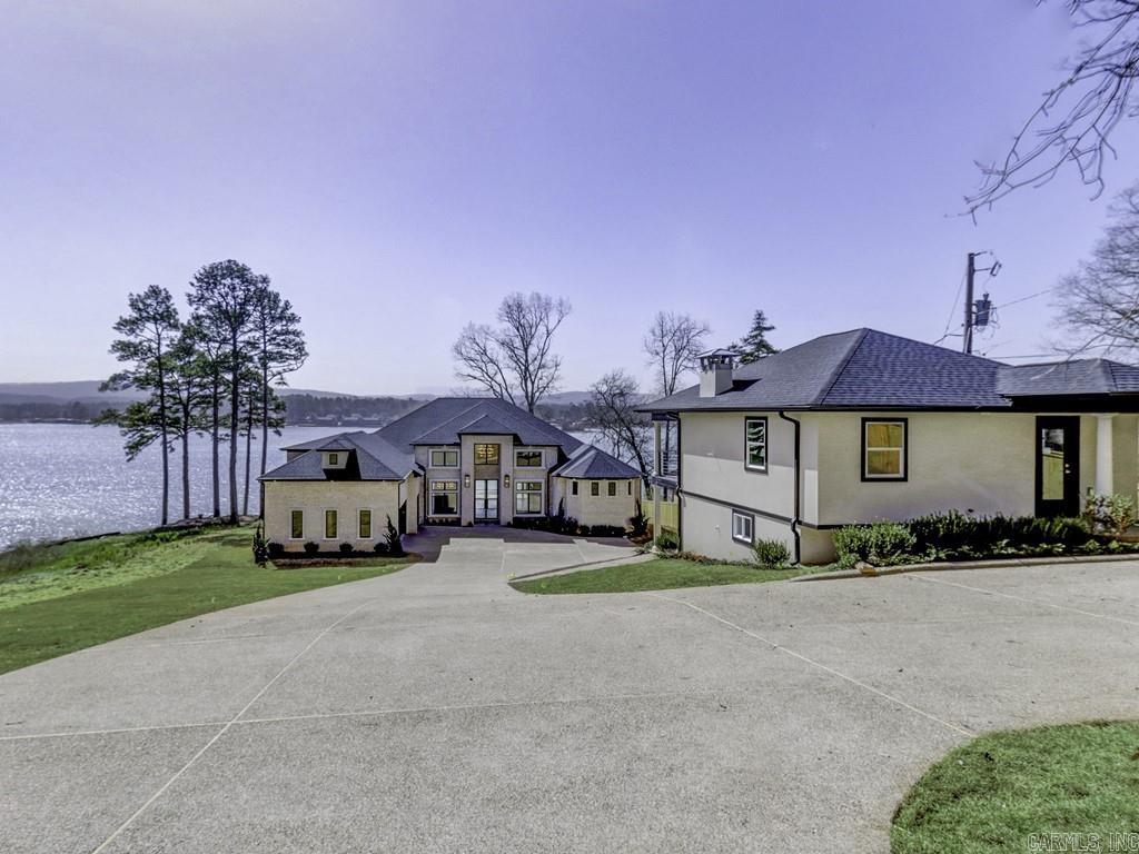 Lake Hamilton Luxury Lake Home.  Stunning views and luxury living at it's finest.  Soaring ceilings and the appointments you are looking for in  your dream home on the lake that includes a guest house.  Floor plan that maximizes views and open spaces perfect for relaxing together and entertaining. The kitchen is a chefs dream with oversized granite island, custom cabinetry, and large pantry.  Beautiful fireplace in the living room for cozy conversations.  The main ensuite features a coffee bar, fireplace and sumptuous bathroom, including his and hers potty rooms. Closets thoughtfully designed and offer and place for everything. Upstairs is a great game room, bedroom, and bathroom. The outdoor kitchen is perfect for lakeside entertaining and includes a fireplace.  A double stall boat dock is included.  The guest house has two levels. The upper level includes 1 bedroom, 1 bathroom, kitchen and is 632 sq. ft.  The lower level is 572 sq. ft. includes 1 bedroom, 1 bathroom and kitchen.  Close to Garvan Gardens and the tranquil lake life you have been dreaming of.