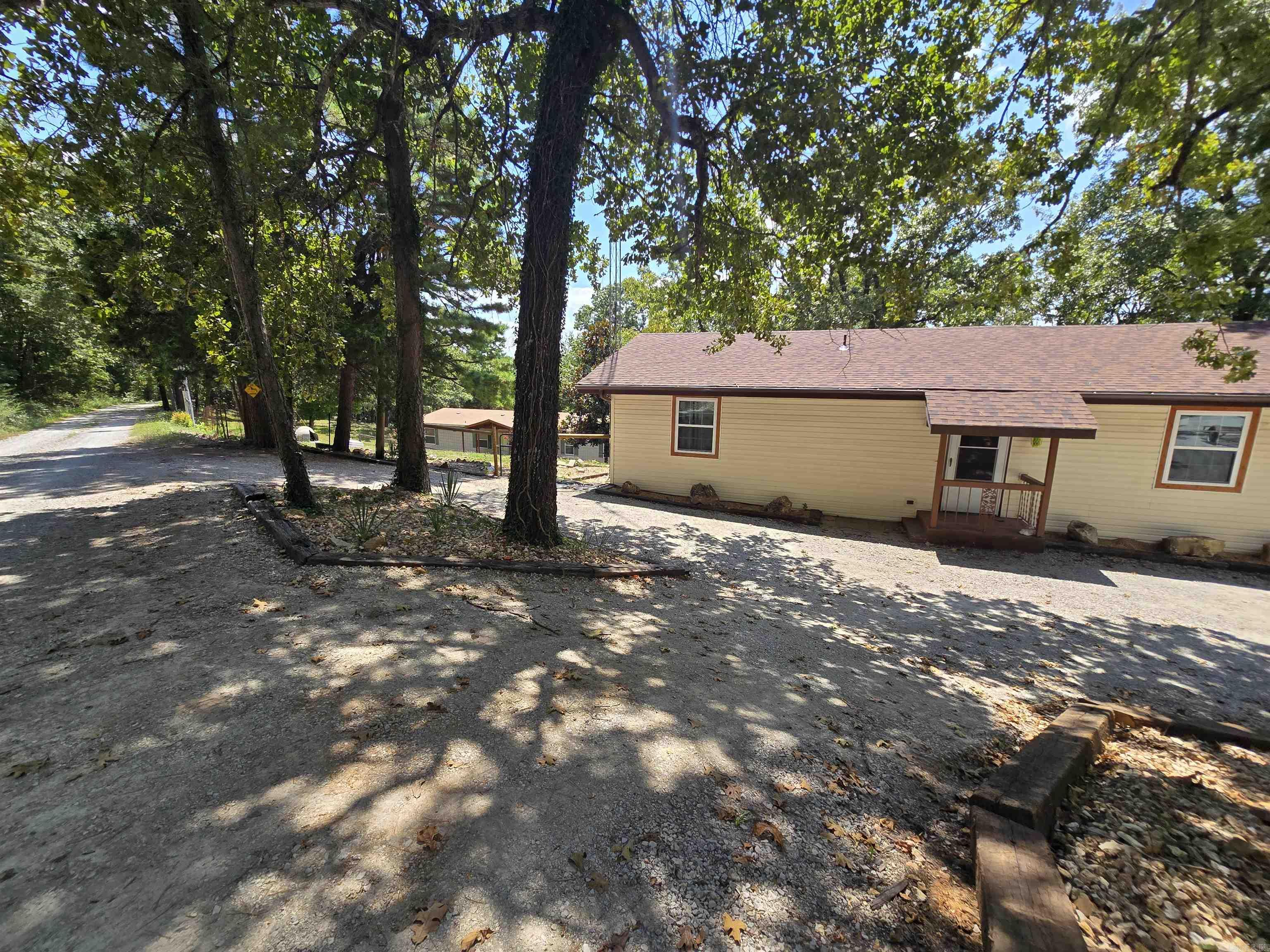 Two homes on nearly 7 acres! The charming main home features 3 bedrooms, 2 bathrooms, a partial basement, and a workshop—plus a screened-in porch overlooking the spacious backyard. The guest home is a 4-bed, 2-bath manufactured home on a permanent foundation, perfect for extended family, rental income, or extra space. Enjoy peaceful country living with modern updates, including a brand-new well and a roof that's less than a year old. The 6.98-acre property offers privacy, open space, and endless potential for gardening, hobbies, or outdoor fun. Located near Lake Norfork and Pigeon Creek for boating, fishing, and recreation. This is an ideal setup for multi-generational living or investment opportunities. Don't miss this rare find—two homes, acreage, and natural beauty for just $425,000.