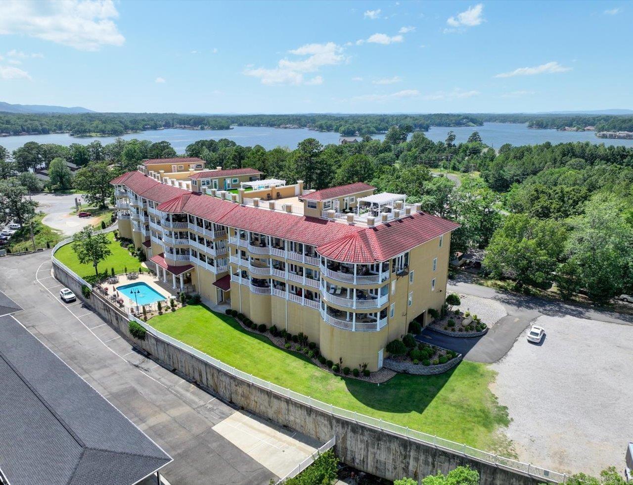 Luxury Lakefront Living on Lake Hamilton – Fully Upgraded with Rooftop Entertaining Space  Experience elevated lakefront living at its finest on St. John’s Island, where breathtaking 180-degree views of Lake Hamilton set the stage for a truly exceptional lifestyle. This luxury condo offers a seamless blend of refined interior finishes, expansive outdoor living, and over $85,000 in recent interior upgrades, along with major building-wide improvements, making it a standout opportunity for both full-time living and vacation ownership.  From the moment you enter, you are welcomed by panoramic lake views through oversized windows, filling the space with natural light and creating a tranquil, resort-style atmosphere. The open-concept living area flows effortlessly onto a private balcony overlooking the water, ideal for morning coffee or evening relaxation.  The interior showcases high-end finishes throughout, including granite countertops, stainless steel appliances, travertine flooring, and updated fixtures. The kitchen has been enhanced with freshly updated cabinetry and lighting, creating a clean, modern aesthetic that complements the home’s upscale feel.  The primary suite is a priva