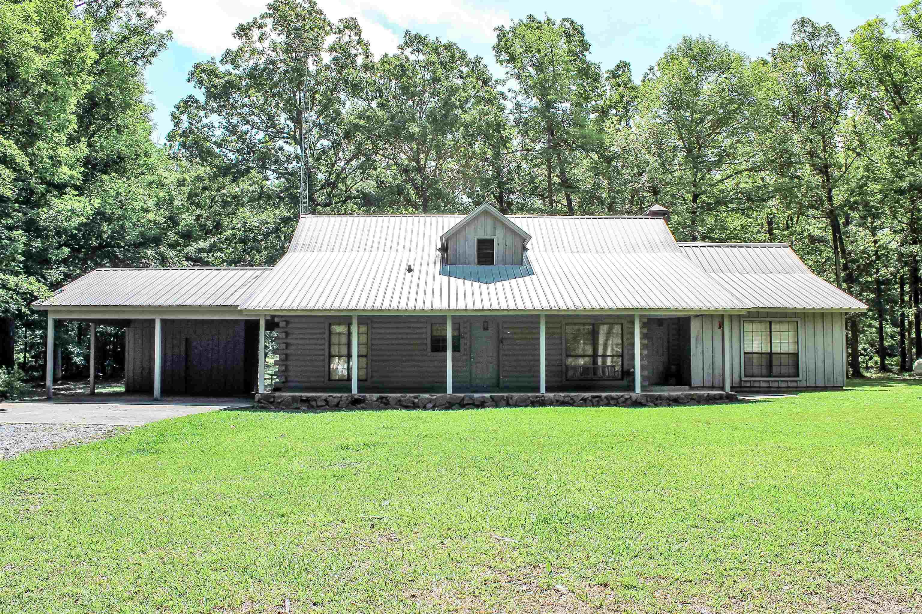 Log home nestled on 6.25 acres with a pond.