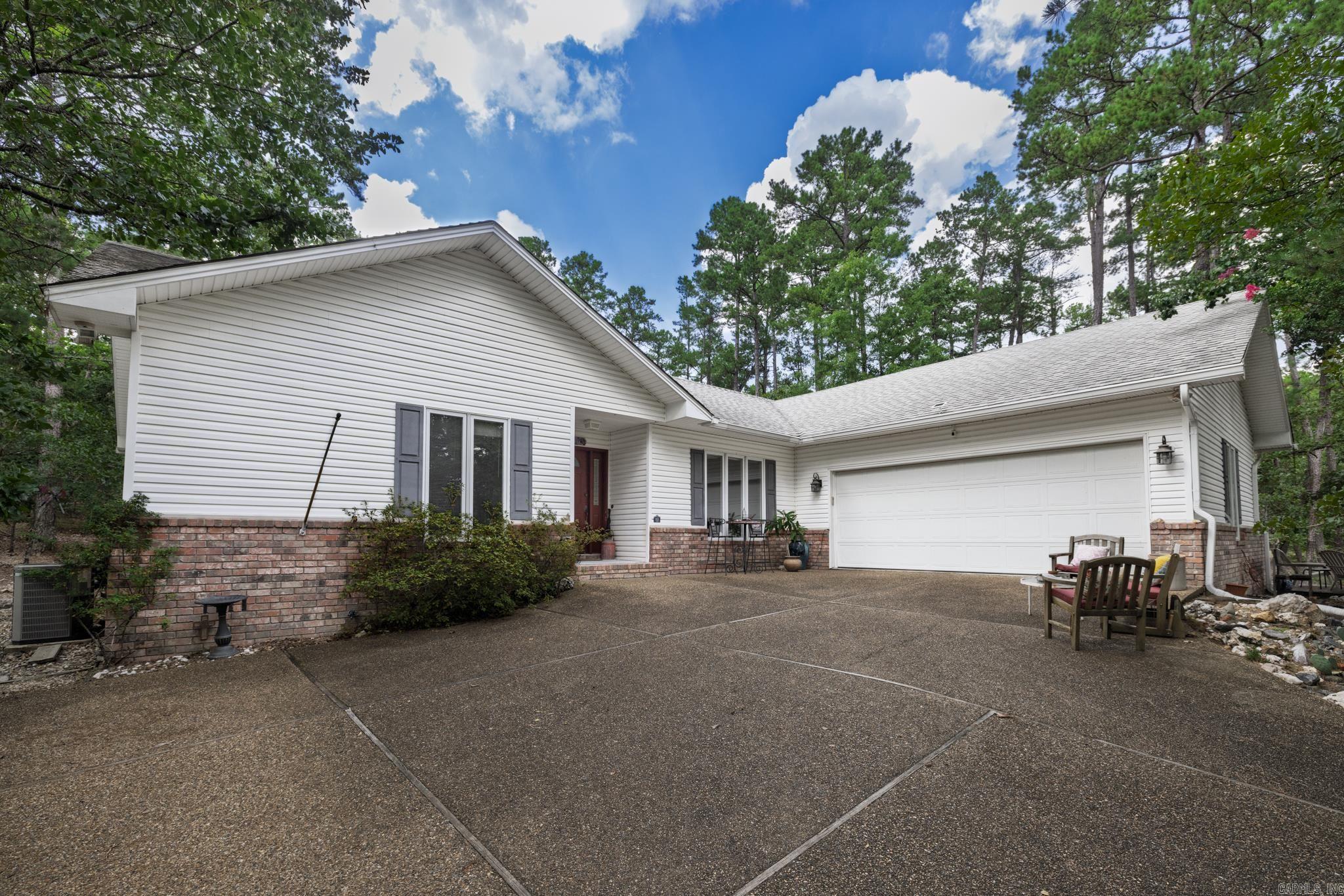 This charming home welcomes you to a living room with vaulted ceilings and skylights.  There is a two-way gas fireplace between the living room and dining room.   Kitchen has more than ample counter space, storage and a seating area overlooking the gardens and a third skylight.  Split floorplan with very large primary featuring ensuite with walk in shower, jetted tub and large closet.   Two guest rooms on the other side of the home with a bath in between.  This home has tile flooring in the kitchen, new LVP in 2021, heat pump new in 2022, newer roof, water heater in 2023 and has been very well maintained.   The gardener will love the back yard with patio, deck, shrubs and flowering plants create a calming retreat.  Hot Springs Village boasts 9 golf courses, 11 lakes, pickleball, hiking trails, white sand beach, tennis, fitness center, play grounds, indoor and outdoor pool. You will enjoy our dog park, entertainment center, excellent fitness center, and farmers market.  HSV has one time $2000 buy in for new residents.