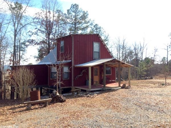 Cabin on a hilltop with views.  This 2 bedroom 1 and a half bath cabin is nicely appointed and has breathtaking views from the deck.  All the comforts of home including a picturesque wood stove, full kitchen, washer and dryer and more are here and the cabin comes furnished.   Sitting atop its very own knoll, the guest cabin has its own bedroom and bath and includes a porch, deck and outdoor shower!  Paved road access only 15 minutes from Mena.  RV Hookup, 1,200 gallon septic tank, all with 12.6 acres.