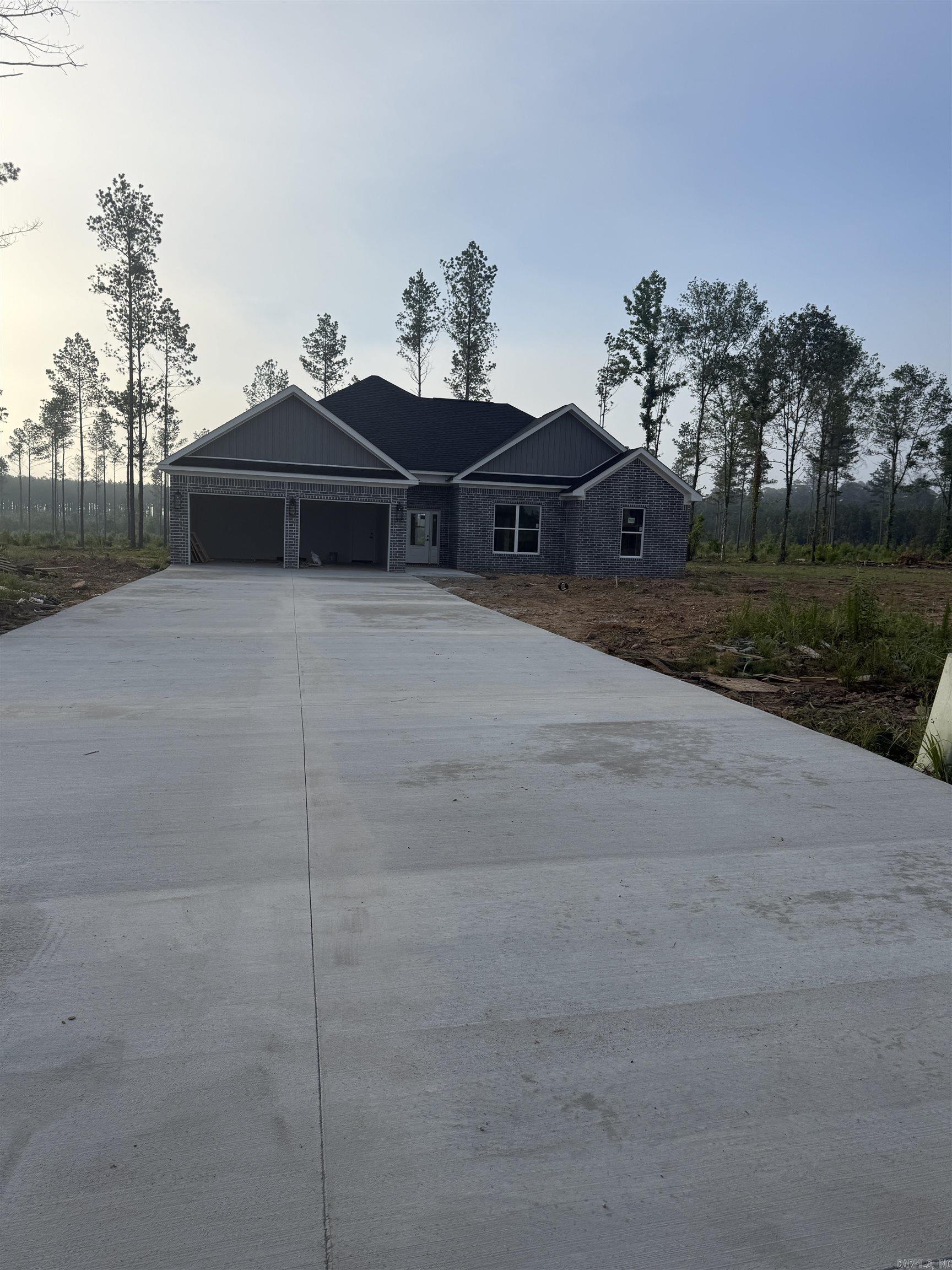 New construction 3 bedroom, 2 bath home on 3.09 acres in Grant County, just minutes from Sheridan.   This open-concept floor plan features vaulted ceilings with stained beam, wood-look floors, recessed lighting and a custom fireplace that anchors the living room. The kitchen offers dark custom cabinetry, granite countertops, large island with seating and stainless appliances, all open to the dining area for easy entertaining.   Relax in the spa-like primary suite with a tiled walk-in shower and glass enclosure, dramatic black-tiled surround and freestanding soaking tub, plus an oversized walk-in closet with built-ins.   Split floor plan places two guest bedrooms and a full bath on the opposite side of the home for added privacy. Brick and siding exterior, covered front entry and a spacious 3.09-acre lot provide room for a shop, pool, garden or animals while you enjoy the low-maintenance benefits and energy efficiency of brand-new construction.