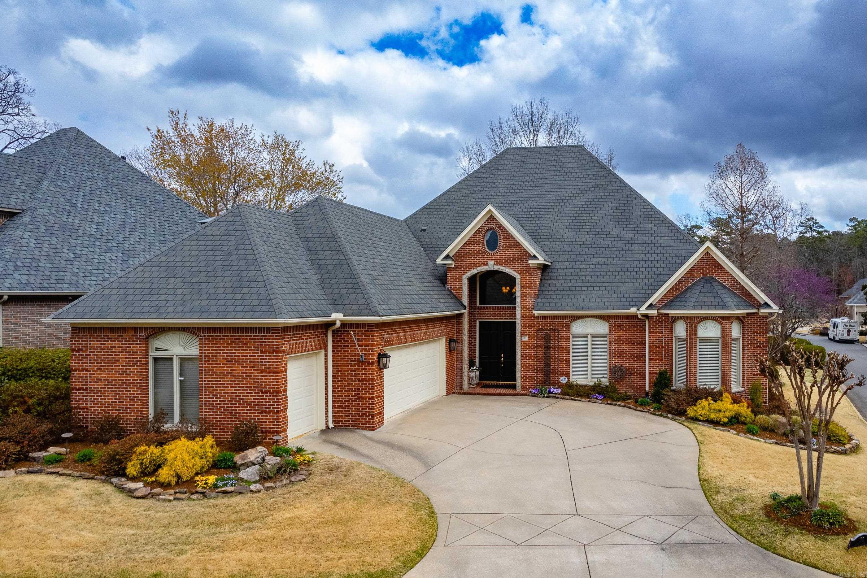 Elegant one story all brick home with tall ceilings, abundant natural light, and beautiful mill work throughout. Welcoming entry opens to gracious living spaces with wood floors and a spacious living room featuring fireplace and custom built ins. Formal dining offers a classic setting for entertaining and flows easily into the fantastic kitchen with abundant cabinetry, generous counter space, gas cooktop, double ovens, breakfast bar seating, and a comfortable keeping room with built ins and large windows. The primary suite is a wonderful retreat with sitting area and serene bath featuring soaking tub, glass shower, dual vanities with dressing space, and a large walk in closet. Two guest bedrooms are privately situated down a separate hall and share a well appointed bath. Covered back deck provides a great space for relaxing or entertaining and overlooks the beautifully landscaped yard and neighborhood creek. Laundry room with sink and nearby half bath add convenience. Gated setting offers privacy and security. Come see!
