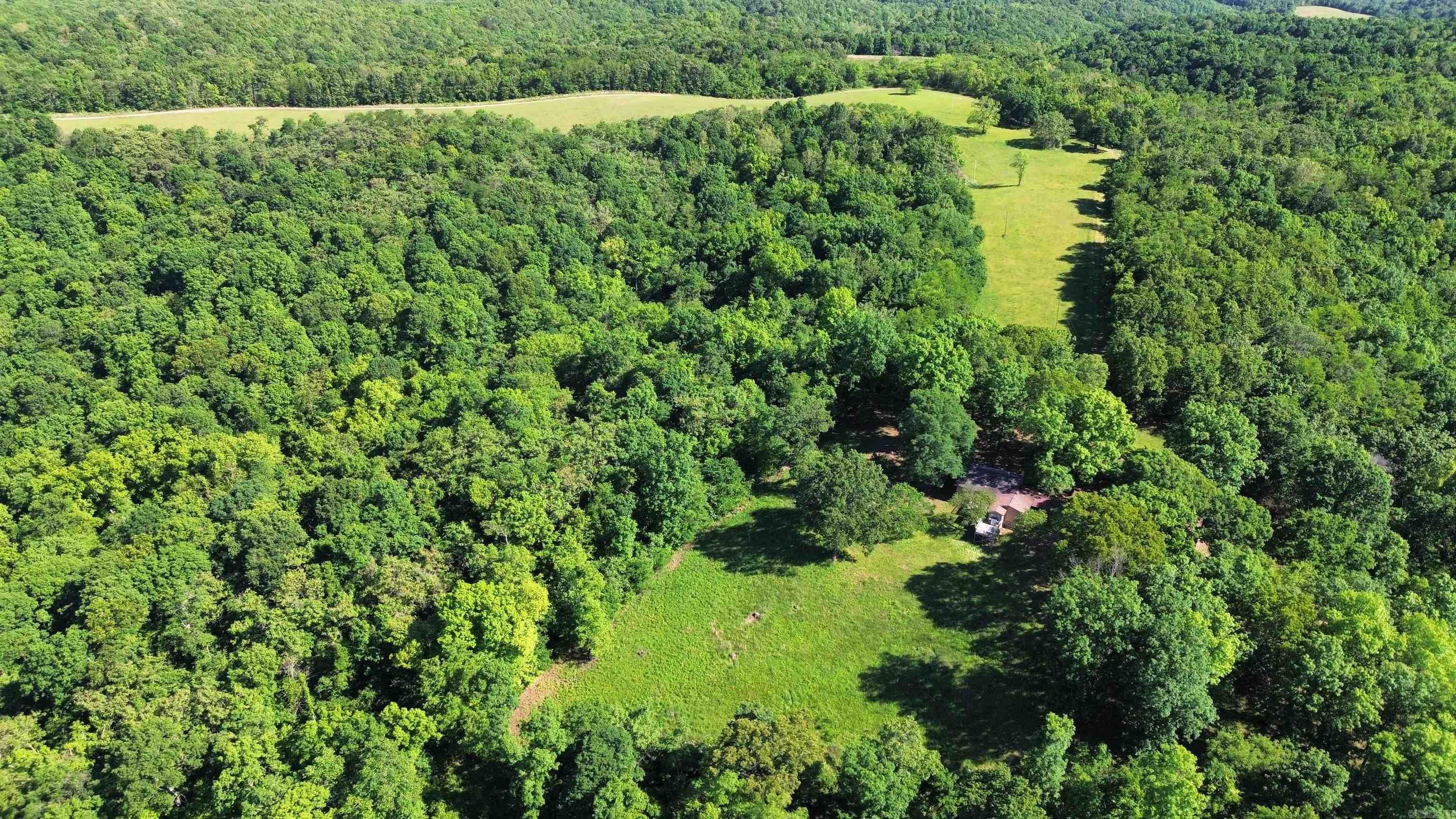 Explore the allure of the Ozark Mountains with this expansive 833.66-acre property, perfectly positioned near communities like Mountain View, Melbourne, and Batesville. Offering an exceptional mix of seclusion and community access, enjoy the essentials nearby while maintaining the privacy of your own vast retreat. This property is an outdoor enthusiast’s dream, rich in diverse opportunities such as hunting, farming, and timber management. The White River is just a stone’s throw away for fishing, and Guion Park provides a serene setting for leisurely walks, merging recreational activities with profitable land management. Inside the welcoming residence, find three cozy bedrooms, including a spacious primary bedroom, and two well-appointed bathrooms. The home fosters a warm atmosphere for both relaxation and social gatherings. Notable amenities include a wood-burning fireplace and efficient central heating and air conditioning, supplemented by a full-house propane generator.   The owners are open to subdividing the acreage, all Priced at $1,250,000.