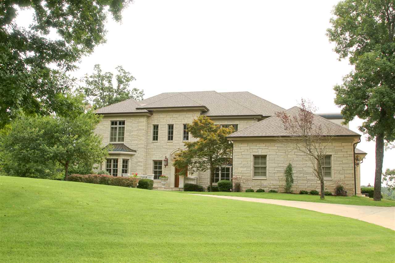 The moment you cross the arched opening and enter the 2 story entry hall through the mahogany door, you'll be awed with elegance. A beautiful winding staircase and stunning crystal chandelier frame the Palladian windows of the Grand Living Room that overlooks the manicured lawn, lake with quaint dock, and spa adjoining the saltwater pool. The dining area is large enough for a banquet and joins the refreshed kitchen with 6-burner WOLF gas cooktop, double oven with warmer, expansive granite, and stone detail.