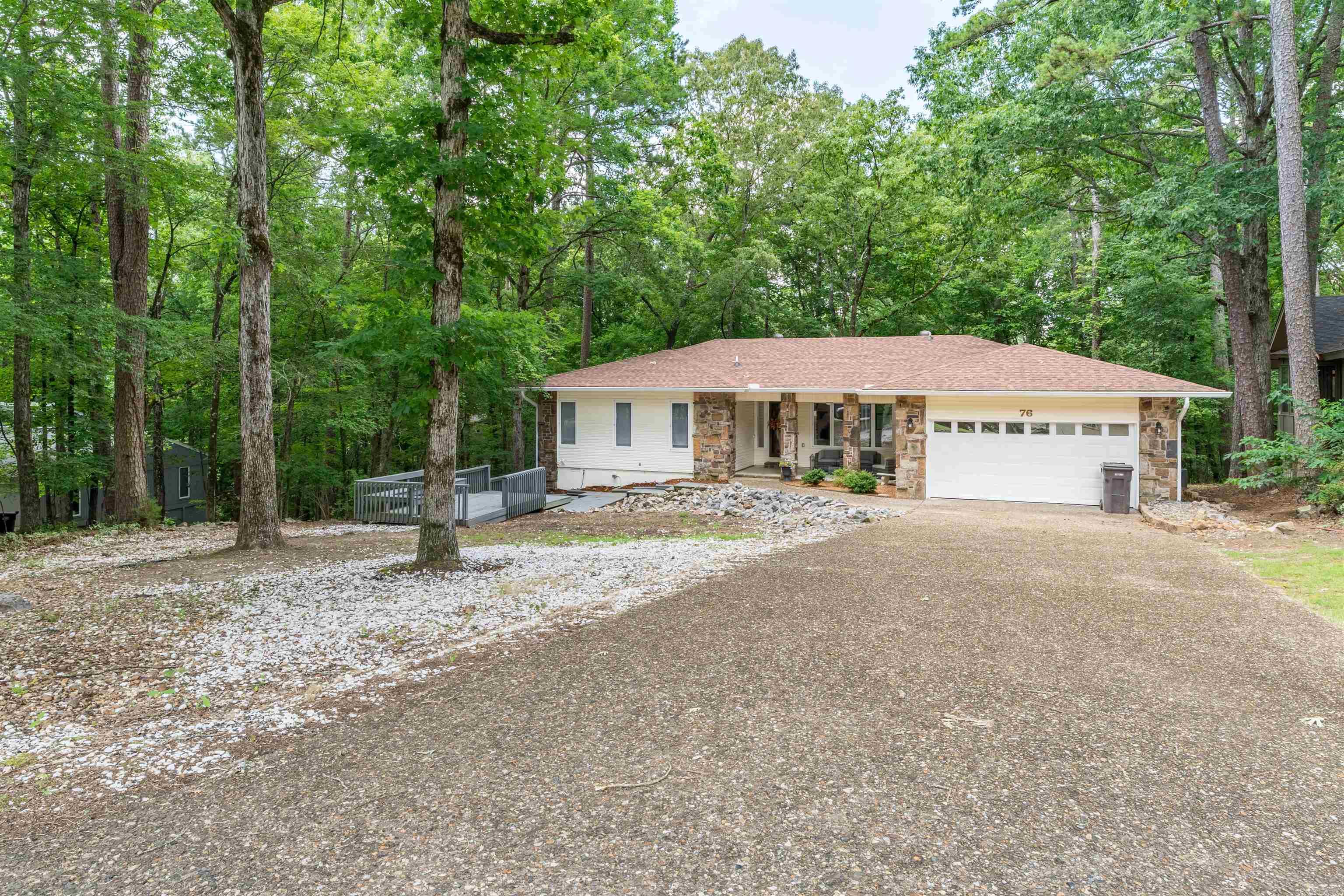 This home has been totally rebuilt...NEW roof, NEW electrical system and breaker box, NEW HVAC, NEW kitchen countertops, NEW appliances, NEW floors, fresh paint and stylish new light fixtures! Wood beams accent the main living area, with windows showing off the fantastic trees from the Arkansas room! The bathrooms are totally remodeled! The primary bedroom with ensuite and a guest room are on the entry level, along with the large hall guest bath. Follow the path to the side of the house to find a newly painted studio apartment complete with a kitchenette and full bathroom. Could be used for multi-generational families or as rental income. Don't forget the NEW garage door and opener. This tree lined street is welcoming and shaded. And the driveway can accommodate multiple cars when family is over! Schedule your showing today!