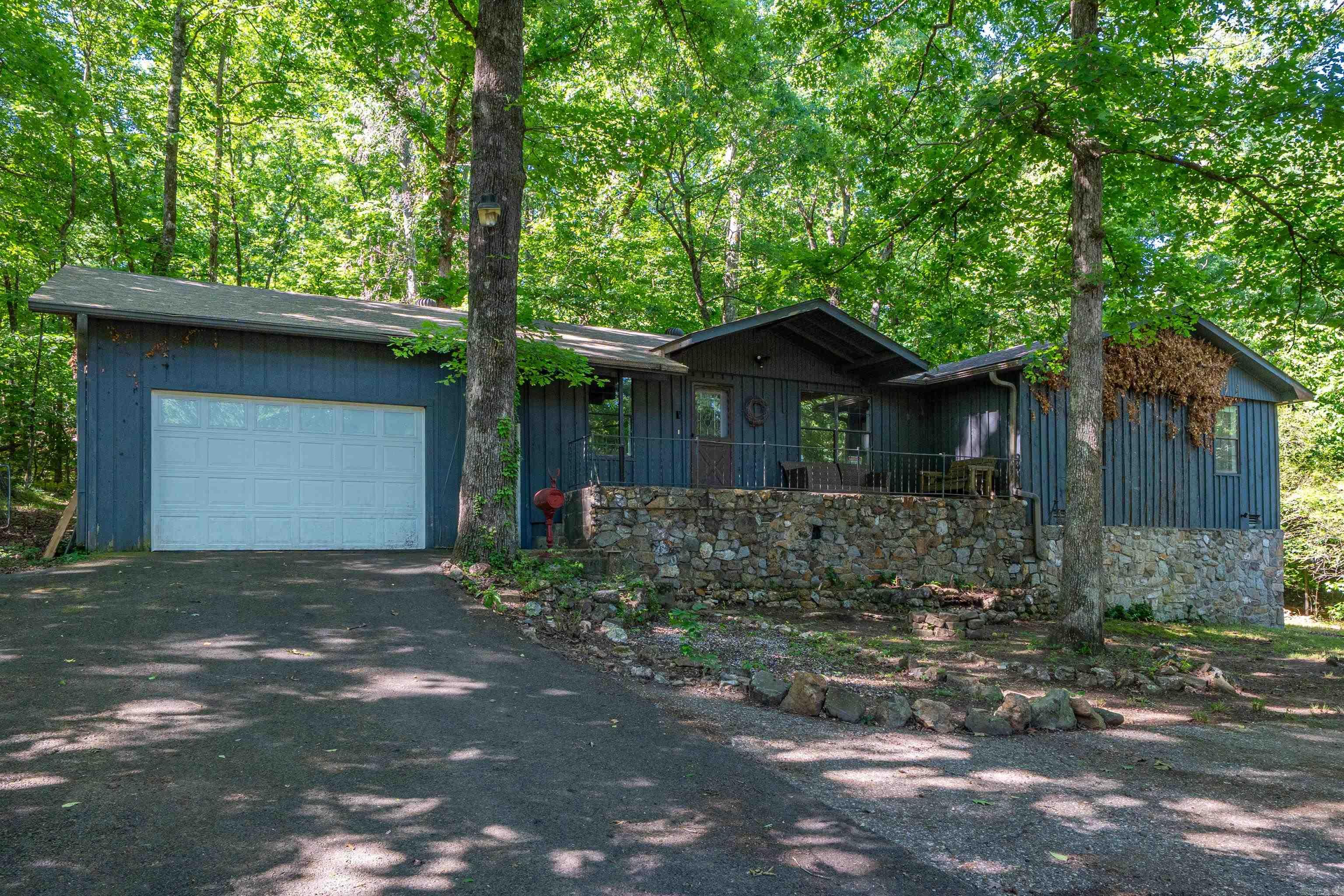 The epitome of natural living, this home is completely surrounded by trees and a flowing creek. In addition to a 3 bed, 2 bath home with a two-car garage, it also has a large detached garage that has a mechanic's pit and tons of storage space. Rounding out its unique features, it has 2 RV/boat shelters, all sitting on 1.6 acres of land.