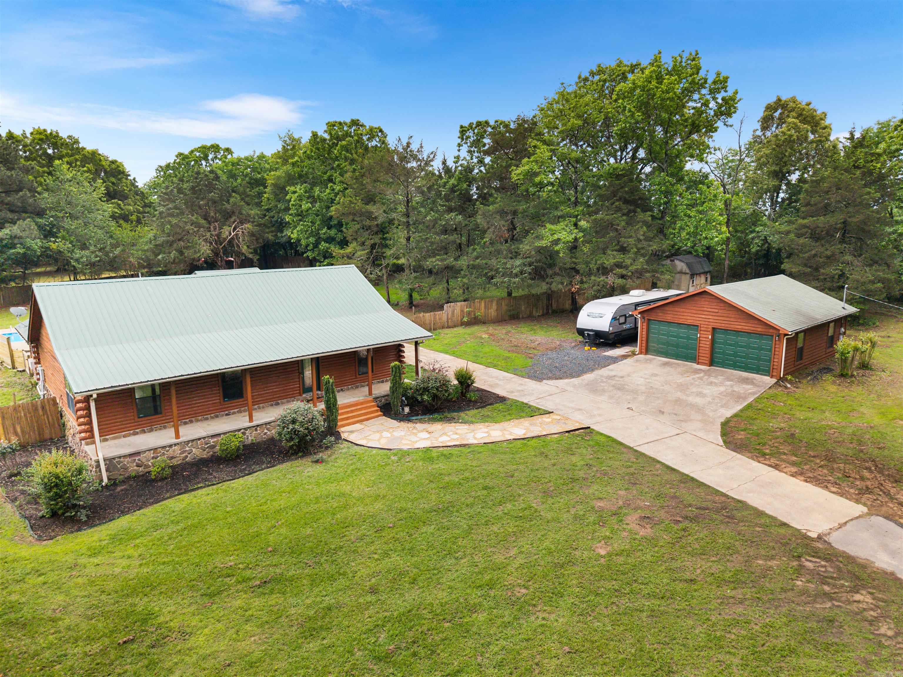 Fully remodeled log cabin home on 1.69 acres with an in-ground pool! This 4-bed/2-bath home offers 1,891 sq. ft. of beautifully updated living space, blending rustic charm with modern finishes. Interior upgrades completed in 2026-all new flooring, fresh paint throughout(including walls, trim, cabinets, & ceilings), newly stained log walls, updated lighting with adjustable settings, added crown molding, new ceiling fans, and stylish finishes throughout. Both function & comfort shine with updated bathrm fixtures, new blinds, & upgraded hardware in every room. Step outside to enjoy a freshly stained and sealed exterior, updated doors with new hardware, enhanced lighting, & a welcoming front porch with new ceiling fans. The property is flanked w/ green space & fully fenced backyard. From the pergola you can enjoy the refreshed in-ground pool that has a new liner, diving board, & equipment updates, plus a newer pump (2023). Add. highlights include a 2-car garage with added lighting, a new RV pad w/ 30-amp hookup, and a storage shed nearby. This move-in ready property offers the perfect mix of peaceful acreage, modern updates, and outdoor living-don't miss it! 4 Bdrm can be a flex space!