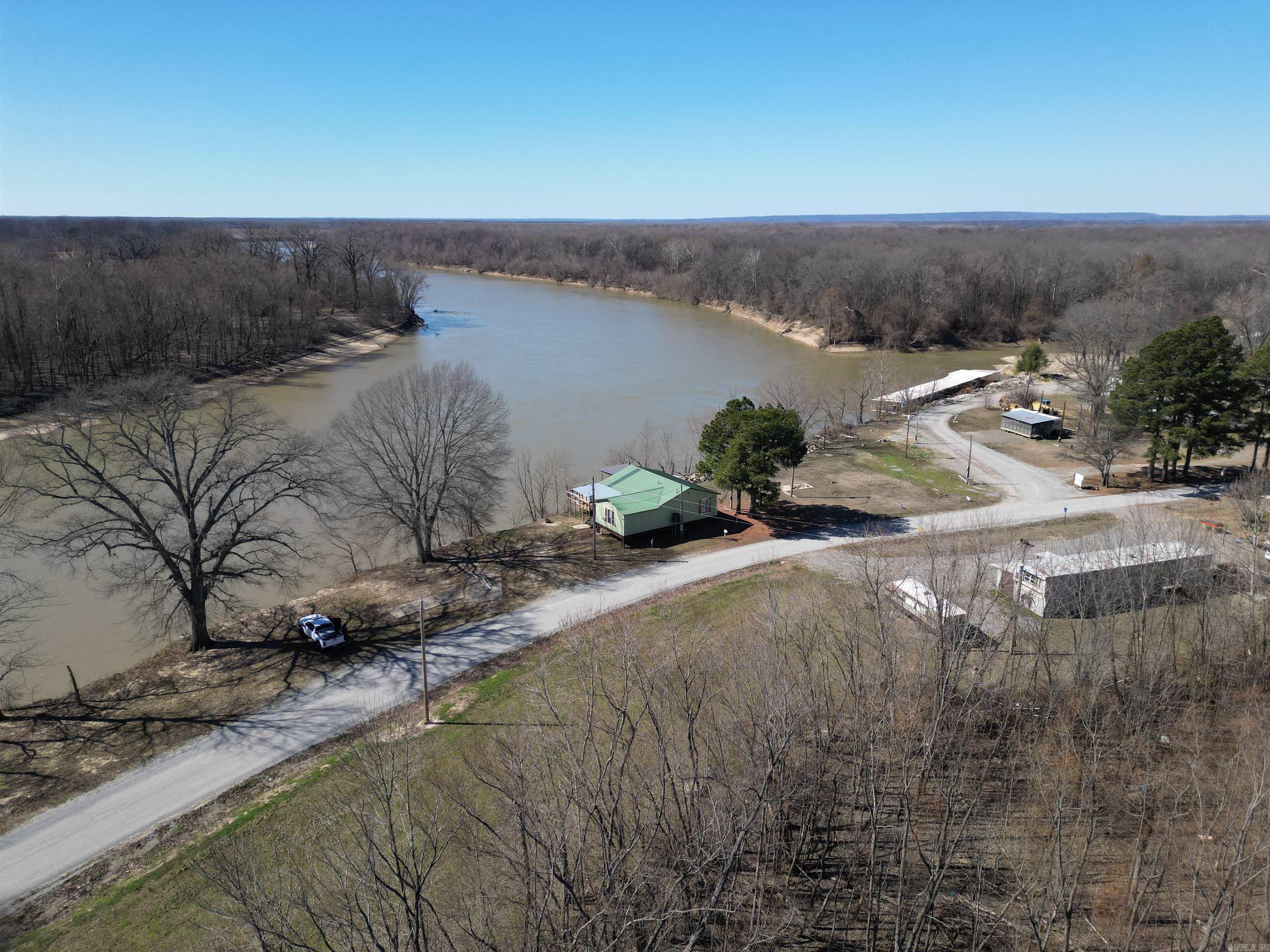 This recently remodeled 2 bedroom, 1.5 bath riverfront home offers comfort, convenience, and serious outdoor opportunity.  The interior has been updated with new flooring, kitchen improvements, refreshed bathrooms, and modern finishes while maintaining a warm, rustic feel. A full wall of windows across the back of the home captures panoramic river views and fills the living space with natural light.  Step outside onto the brand-new wrap-around deck, built for entertaining, relaxing, and watching the river roll by. Fish directly from your property or launch your kayak just steps away.  The lot extends on both sides of the road, giving you additional space for parking, boat storage, or an RV setup — ideal for hosting guests during peak seasons.