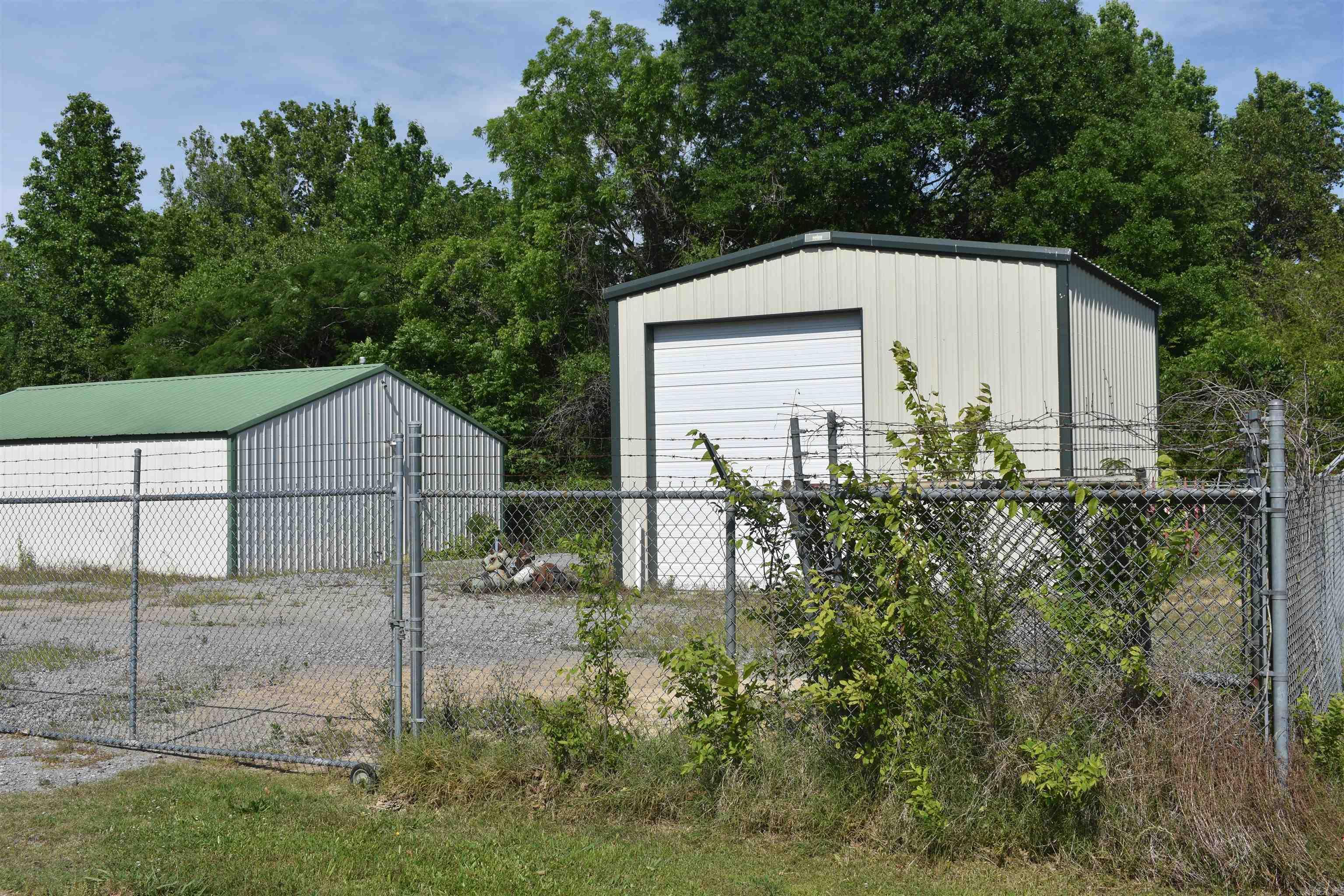 Two metal buildings a 20x20 and a 30x 40 on a gravel lot . The property is fenced with 6 ft. chain link.
