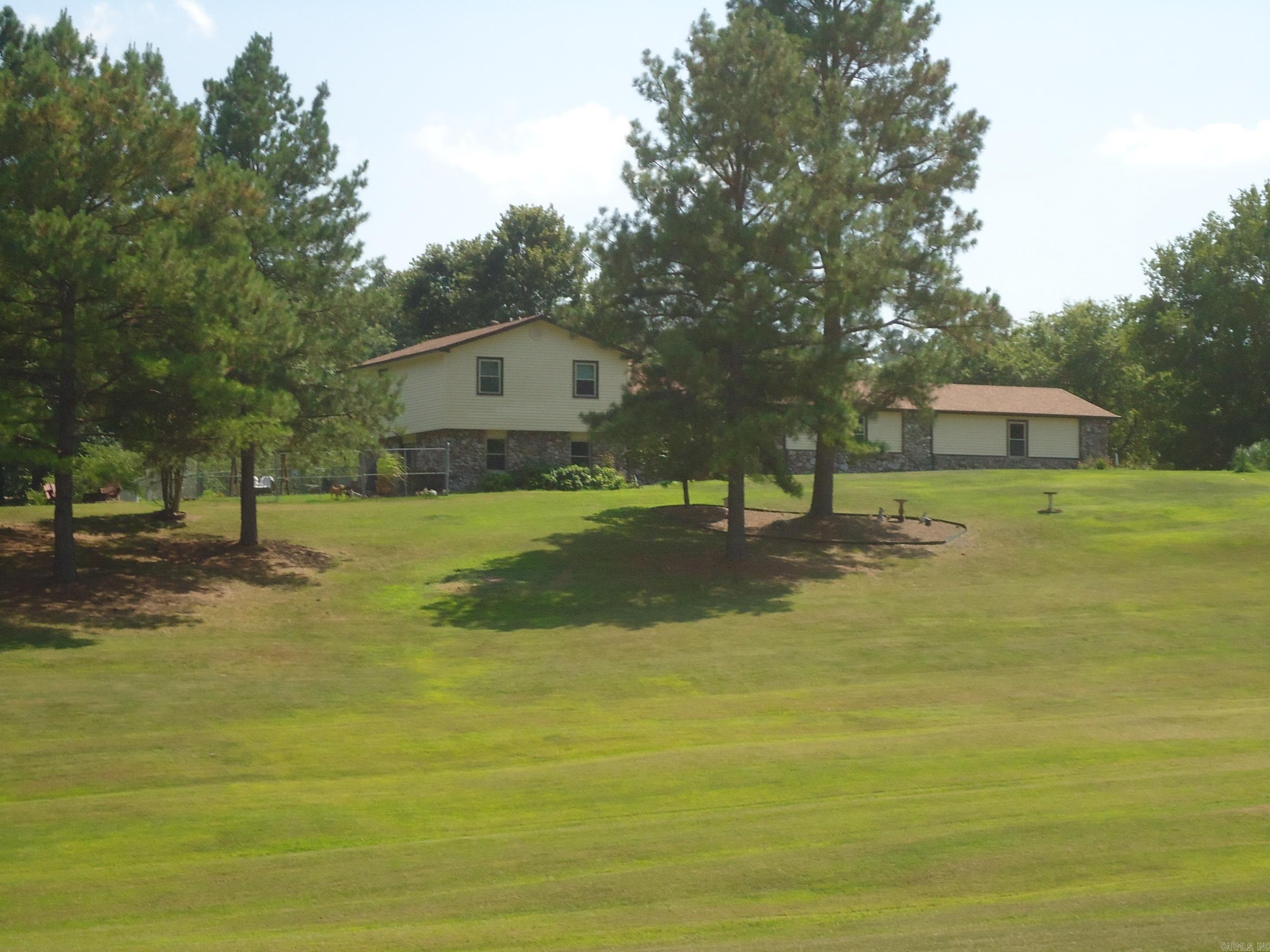 Nice tri-level ranch home siting on a beautiful 4.8-acre land tract. just off North Moore Road. 4 bedrooms and 2.5 baths. Nice size living room with large stone fireplace with gas logs and built ins on both sides. Kitchen with Bay window breakfast area. Cabinets and some appliances have been replaced in the past few years. Refrigerator, washer & dryer remain. Large combination den & formal dining area. Upper level has 3 bedrooms and 2 full baths. Lower lever and an office which could be the 4th bedroom and a large game room for entertaining. Outside concrete patio. Rear of home has a wood covered deck. Oversized 2 car garage with overhead doors. Also paved area for additional parking. Part of back yard is fenced as well as a fenced area on the west side of home. Home sits on a knoll with a beautiful view of the well-kept front acreage.