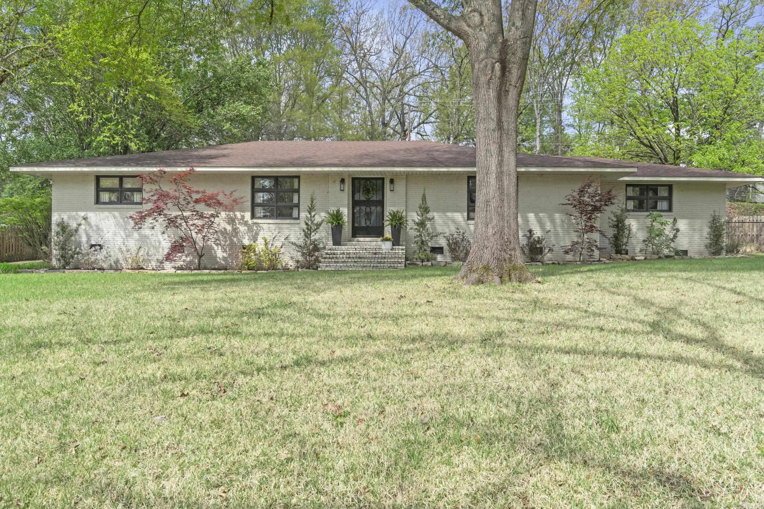 Stunning new listing with exceptional curb appeal, perfectly situated on a private lot on Shannon Drive. This beautifully updated, move-in ready home is a must-see. From the moment you arrive, you’ll notice the lush sodded yard, mature landscaping, and fresh cream brick exterior highlighting its timeless mid-century style.  Inside, a spacious layout offers two inviting living areas, one with a cozy fireplace, plus an eat-in kitchen featuring updated cabinetry, an island, stainless steel appliances, and gorgeous stone countertops. A unique corridor with ample storage connects the spaces, while formal living and dining areas complement the open-concept kitchen and family room.  The split floor plan provides a private primary suite with a full bath and walk-in closet. Two guest bedrooms on the opposite side each offer en-suite baths. A convenient laundry/mudroom adds function.  Enjoy a private fenced backyard with patio and pergola—perfect for relaxing or entertaining. Recent updates include roof, flooring, kitchen, and more!