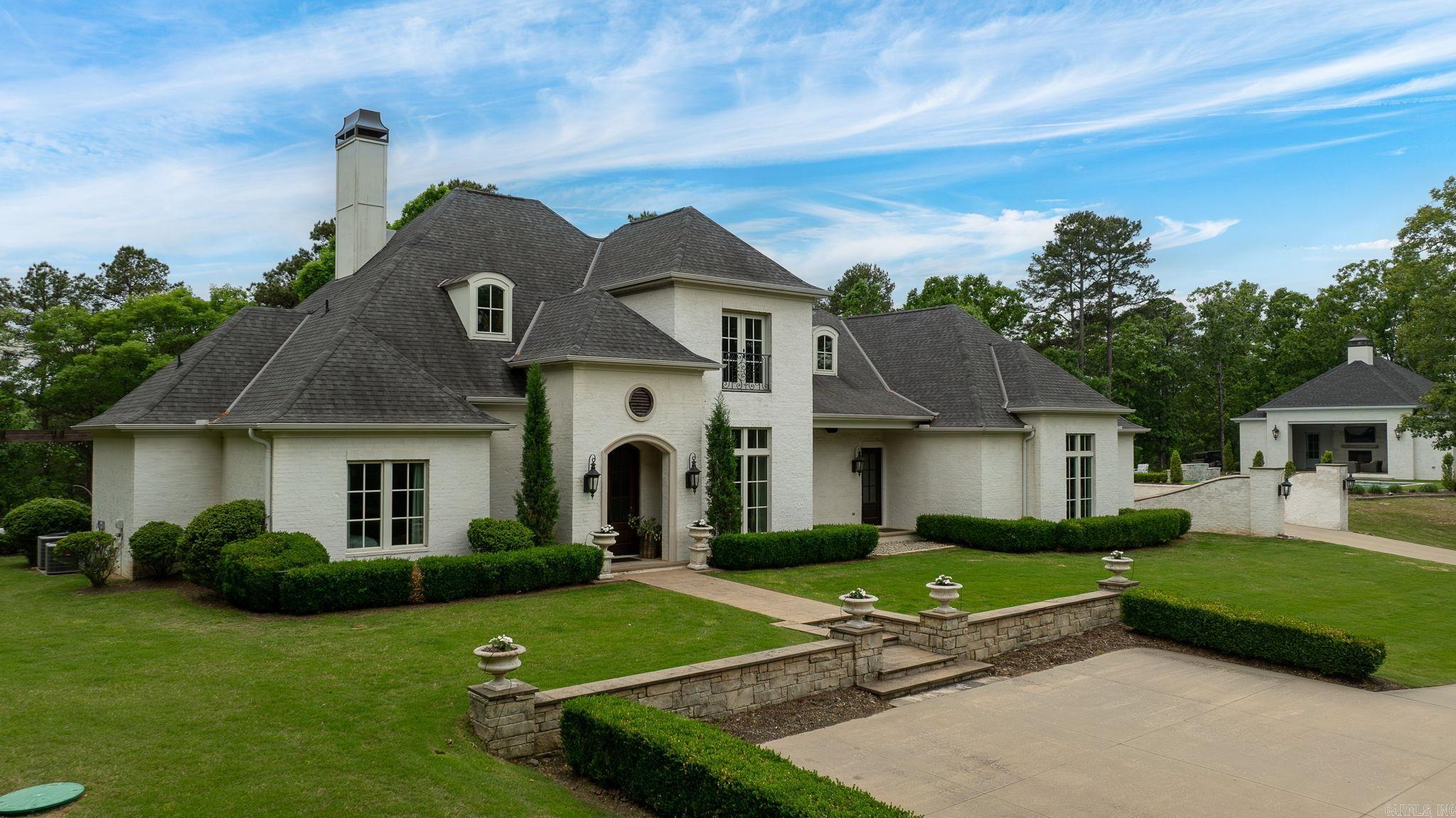 Breathtaking custom home set atop a stunning 5.5AC mountaintop setting offering privacy, views, and exceptional indoor and outdoor living. Designed with both elegance and function in mind, the home flows effortlessly thru-out. The gourmet kitchen features Thermador appliances, handcrafted island accents, and generous cabinetry, opening to inviting living spaces with a fireplace and wall of windows overlooking the landscaped grounds. The main level primary suite is privately positioned with two closets and a refined bath, while two guest bedrooms share a jack and jill bath. Upstairs offers two additional guest bedrooms and a spacious bath. The current owners have made enhancements, including adding an impressive family room with fireplace, custom built-ins, and access to a 420sf home gym/4th garage bay. An oversized detached three car garage was added with a 440sf bonus room and storage. Outdoor living is exceptional with an in ground pool and a beautifully designed 735sf pool house offering a 580sf covered patio with fireplace, grill, and hot tub, plus a kitchenette, full bath, stacked laundry, and flexible living/sleeping space. Main house 4918sf +1585sf additional.  Come see!