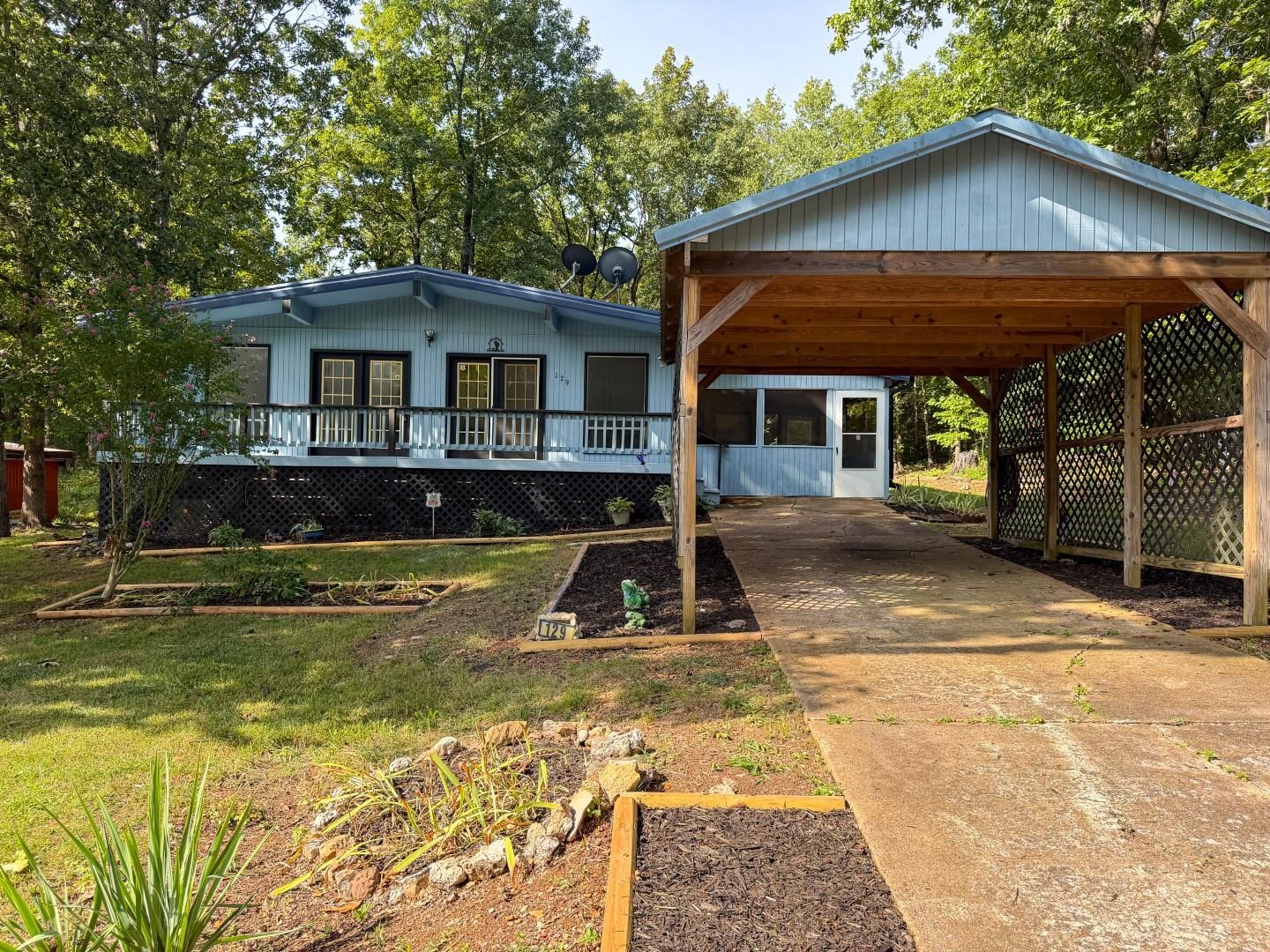 Here is your opportunity to own a charming 2-bedroom, 1-bath mid-century style home in beautiful Cherokee Village! Freshly repainted throughout, this move-in ready home boasts wood-beam ceilings, new flooring, a dedicated laundry room, and a striking native stone fireplace as its centerpiece. Floor-to-ceiling windows flood the spacious great room with natural light, bringing the outdoors in. Step outside to a lovely screened-in area—the perfect space for relaxing or entertaining year-round. Cherokee Village property owners enjoy access to 7 private lakes, two 18-hole golf courses, swimming pools, recreation centers, and the South Fork of the Spring River. Whether you’re searching for a serene primary residence, a weekend getaway, this gem is a must-see!