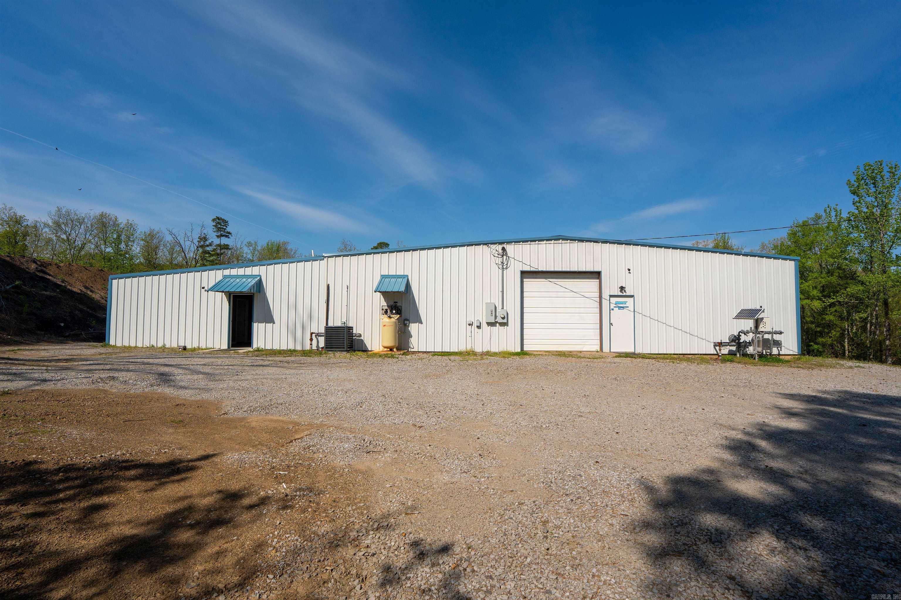 Unique live/work opportunity with endless potential! This versatile property features over 8400 sq ft, 7560 enclosed sq ft , 6,300 of that heated and cooled, and a 900 sq ft covered new slab. The 30x60 fully foamed, heated/cooled shop was built in 2025 and features rooms that could become an awesome barndominium, hunting cabin, or residence leaving plenty of other work/hobby space in the connected shop. This shop contains a private entrance with two offices/bedrooms, a break room, 2 restrooms, and 2 large heated and cooled work spaces with three phase power and an industrial air compressor with air lines throughout the building. This property is on 2.85 acres with city water/sewer,  multiple roll up doors around the shop, covered outdoor storage area, and contains a functioning shale pit for additional income. This is a rare opportunity to own a property that combines flexibility, convenience, and potential!