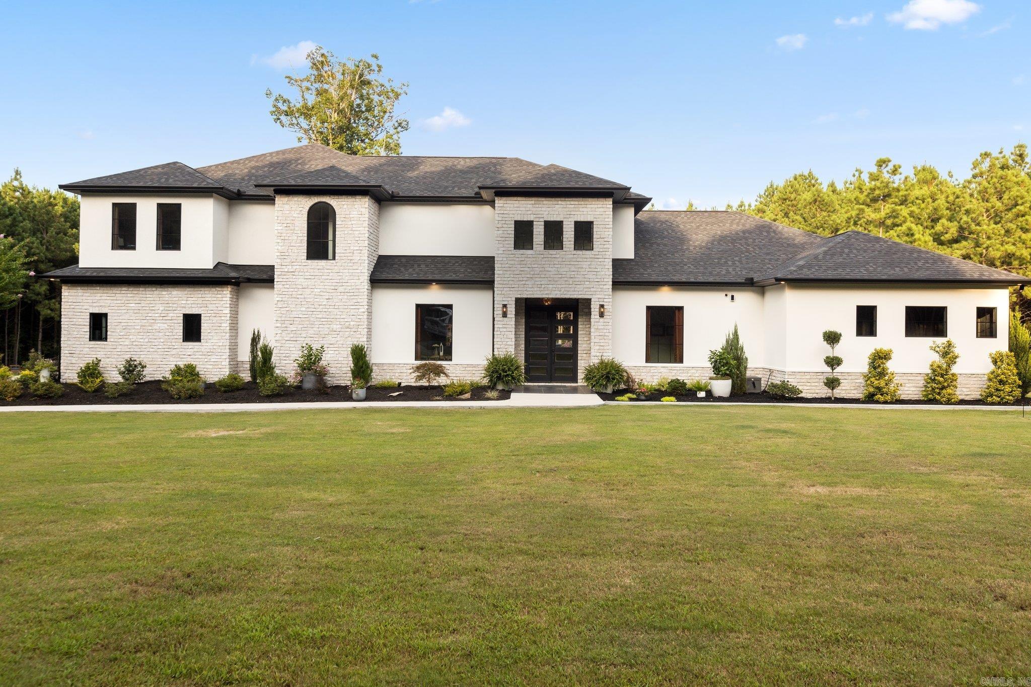 Experience unparalleled luxury in this stunning modern estate, sprawling across 31 acres of pristine land. This home is a true masterpiece, boasting quartz & granite countertops, top-of-the-line lighting, & three gas fireplaces for that perfect touch of warmth & elegance. The chef’s kitchen is a dream come true, with two huge pantries, abundant cabinetry, a breakfast bar, wine fridge, nugget ice maker, double ovens, & a wet bar, everything you need to entertain in style. Retreat to the master suite, a private haven featuring a luxury bath with a walk-through shower, a stand-alone tub, & floating sinks. Upstairs, three spacious bedrooms each have their own full baths, complemented by a shared gaming area, ideal for family fun. The home also offers three living rooms, a formal dining room, an office, & a 20x30 shop for your hobbies & projects. The outdoor space is a true oasis, featuring a gunite pool complete with two stunning water features, a slide for endless fun, & a luxurious hot tub to unwind in after a long day. The grilling porch is equipped with a half bath, fireplace, ceiling heater, and a full kitchen, making it perfect for year-round gatherings. Welcome Home!