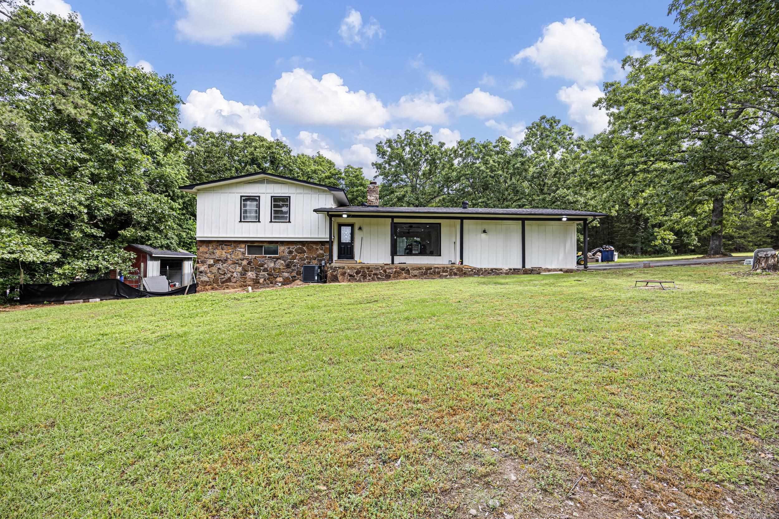 Completely remodeled and move in ready, this 4 bedroom, 3 bath home sits on 4.31 acres offering a mix of cleared yard space and wooded privacy. Two primary suites, one upstairs and one downstairs, provide flexibility for multigenerational living or guests. Updates include new plumbing, HVAC, electrical panel, flooring, and fully renovated bathrooms taken to the studs. Roof is approx. 8 years old. The garage was converted into additional living space, adding versatility. All appliances convey. Updated ceiling fans throughout and hardwired smoke detectors tied into the electrical system add safety. Outside features include a large deck overlooking the acreage, full outdoor lighting, vapor barrier in crawl space, and a security camera system. This property offers acreage, privacy, and modern updates in one package. Additional highlights include open layout, natural light, and peaceful setting close to town. A rare combination of updates, land, and convenience in one property!