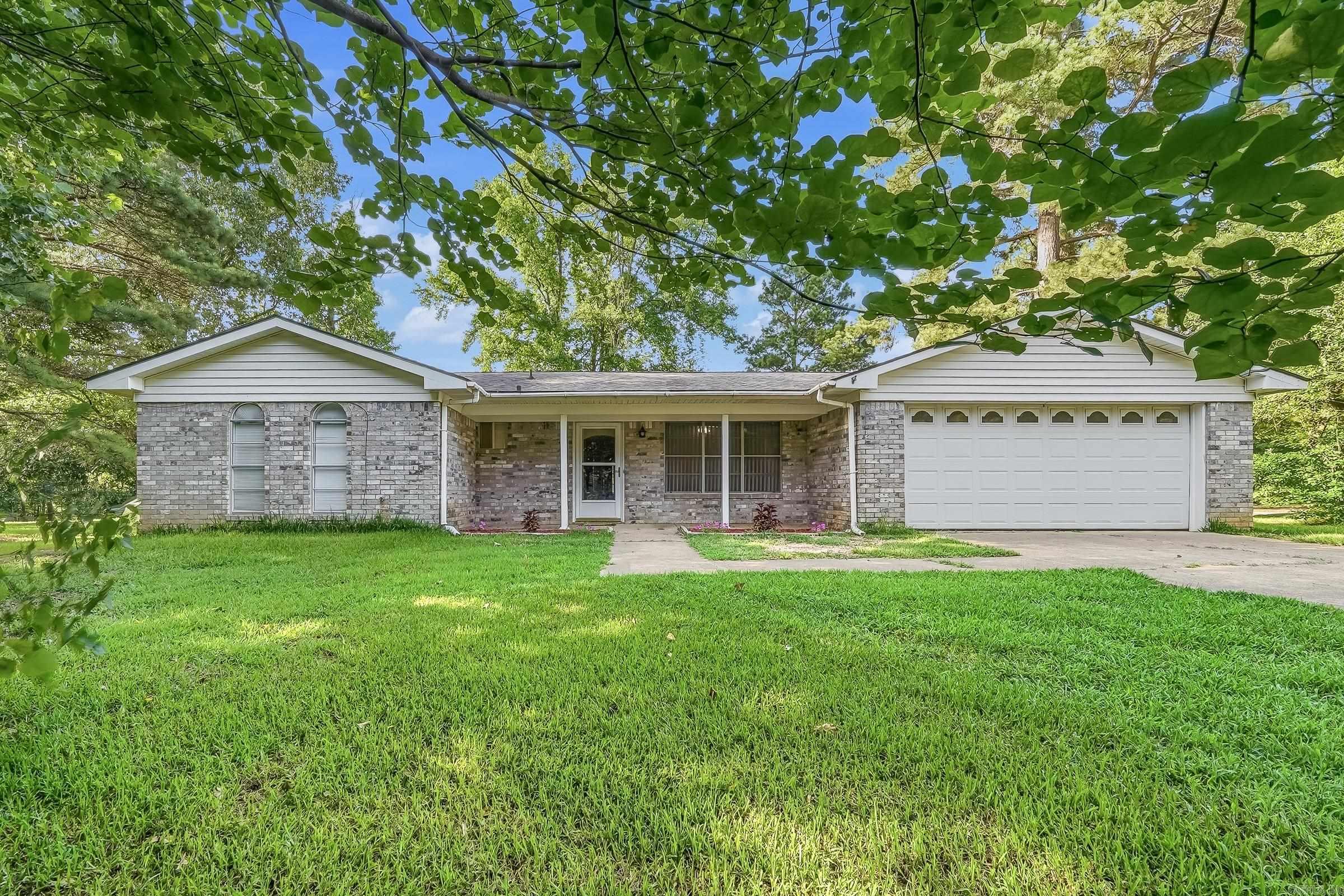 Nestled on approximately 3.36 acres, this 3-bedroom, 2-bath home offers 1,705 square feet of comfortable living space with room to make it your own. One of the standout features is the expansive enclosed sunroom stretching across the back of the home, providing the perfect space for entertaining, relaxing, hobbies, or enjoying peaceful views of the surrounding property year-round. Outside, you'll find a large metal shop with multiple overhead doors, ideal for storing vehicles, equipment, boats, RVs, or creating the ultimate workshop. An additional storage building offers even more space for tools, lawn equipment, or a home office. Mature trees provide shade and privacy while the acreage offers endless possibilities for gardening, recreation, or future improvements. Conveniently located with highway frontage, this property combines country living with easy access to town. If you've been looking for space, storage, and a home full of potential, this one is worth a look!