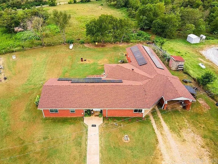 Peaceful country living awaits on 2.21+/- acres near Lake Ouachita. This 3-bedroom, 2-bath home offers approximately 2,013 sq ft in a quiet rural setting, with the Ouachita National Forest, Ouachita River, and Lake Ouachita all within 30 minutes. Inside, enjoy locally milled pine shiplap throughout and a flexible layout with a finished basement for additional living or storage space. The kitchen features abundant cabinetry, generous counter space, warm wood finishes, updated backsplash and flooring, plus an energy-saving dishwasher. Energy-efficient solar panels (2021) keep electric costs around $18/month, complemented by blown-in attic insulation and a mini-split HVAC system, with propane and electric heating options. This property includes three water sources: city water (in use), an electric well, and an enclosed hand-drawn well. Outside, you’ll find a raised garden, chicken coop, and multiple carports with space for up to 5 vehicles, all set among scenic mountain views