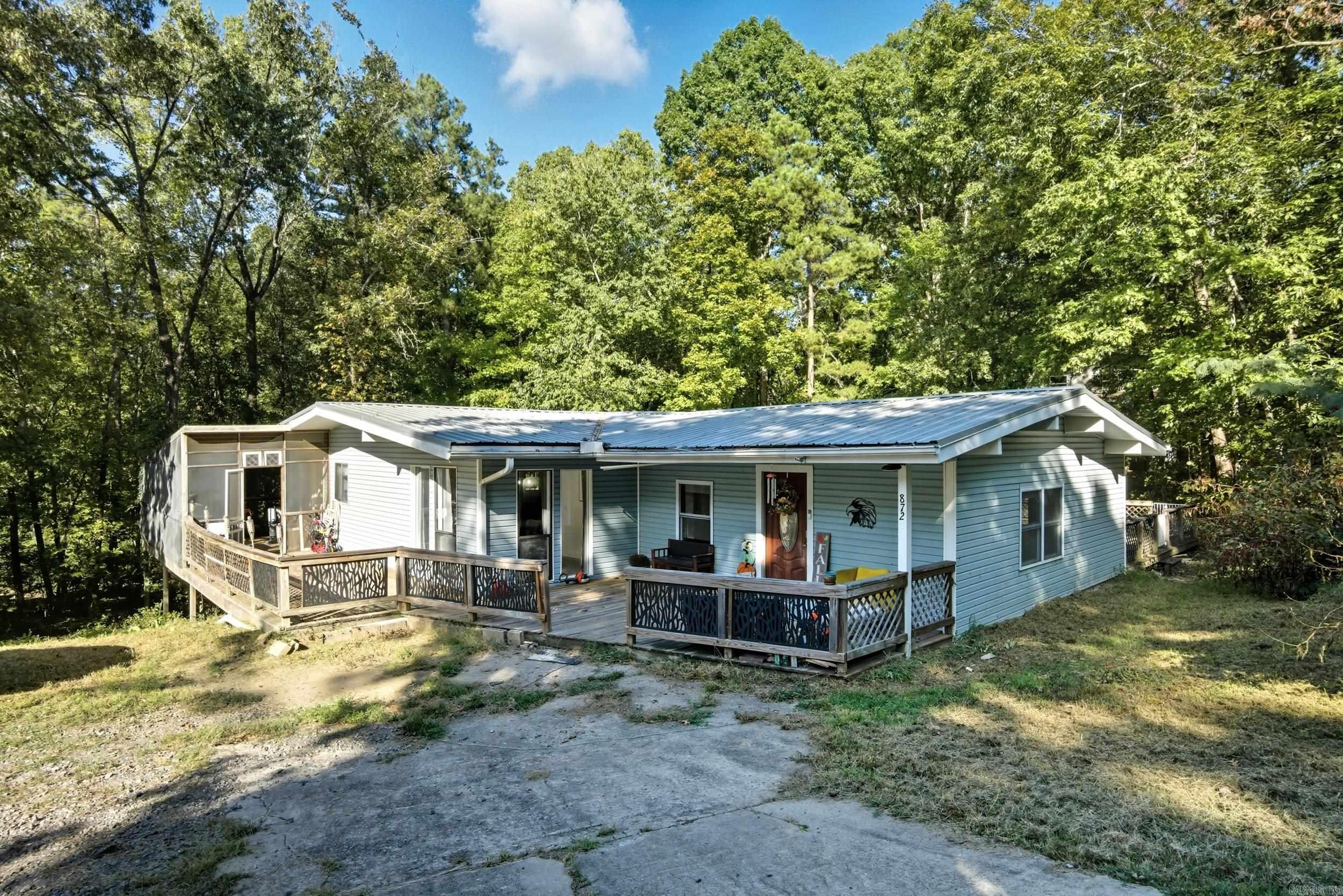 Perched on a hill in the heart of Heber Springs, this beautifully updated home offers privacy and charm surrounded by mature trees. Enjoy peaceful views from the spacious wraparound porch, perfect for morning coffee or evening sunsets. Inside features modern updates and a warm, inviting feel throughout. Conveniently located just minutes from town, Greers Ferry Lake, and the Little Red River. See Remarks.