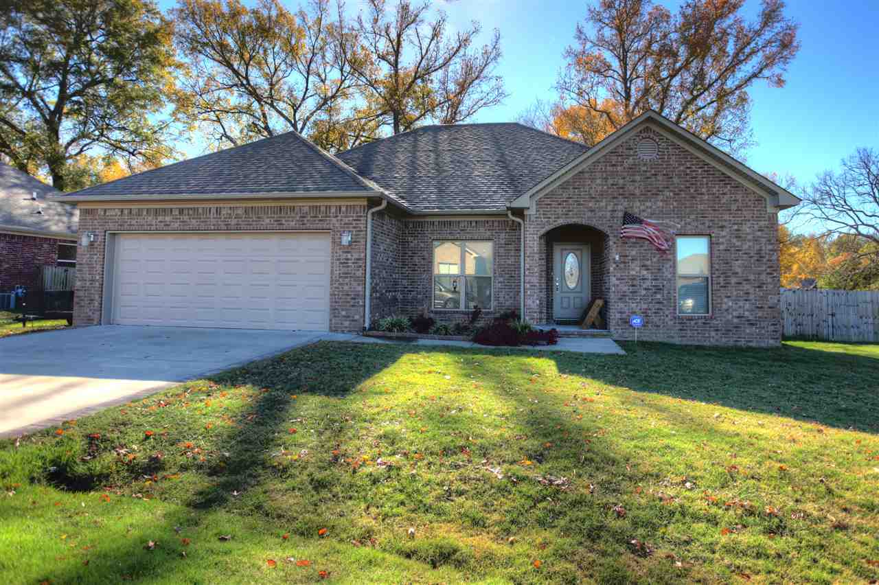 Gorgeous well kept home only 5 years old!!!  Nice lot with privacy fence and wooden play set will convey.  (A $2500 value).  Stunning hand scraped hard wood floors, mantel gas log fireplace, raised bar, open split floor plan, central vac system, fridge will convey, beautiful Corian counter tops and so much more!!  Just a tip tope outside of city limits makes this location quiet, private, and still close to everything!  Peaceful and well maintained neighborhood is warm and inviting!  Come see it today!