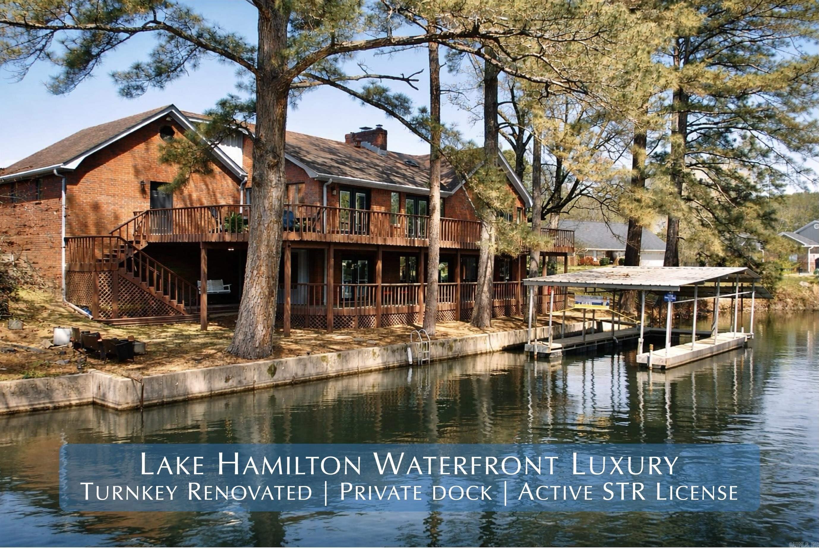 Welcome to an exceptional waterfront opportunity on Lake Hamilton - a fully updated 5-bedroom, 3.5-bath residence with an active short-term rental (STR) license in place, offering immediate income potential from day one. Ideally situated on a quiet cul-de-sac in one of Hot Springs’ most desirable lakefront communities, this property seamlessly blends luxury living with proven investment capability.  Spanning approximately 3,416 square feet, the home has been thoughtfully renovated to deliver a clean, modern, and completely move-in-ready experience. Recent upgrades include all new flooring, fresh interior and exterior paint, updated interior and exterior lighting, and elegant granite countertops throughout the kitchen and bathrooms. The kitchen is further enhanced with new appliances and refined finishes, while the bathrooms feature updated glass-enclosed showers, adding a polished, upscale feel.  What truly sets this property apart is its rare combination of an active STR license and transferable covered boat dock—a highly sought-after pairing on Lake Hamilton that positions this home for both strong rental demand and long-term value. The spacious, well-designed layout comfortably
