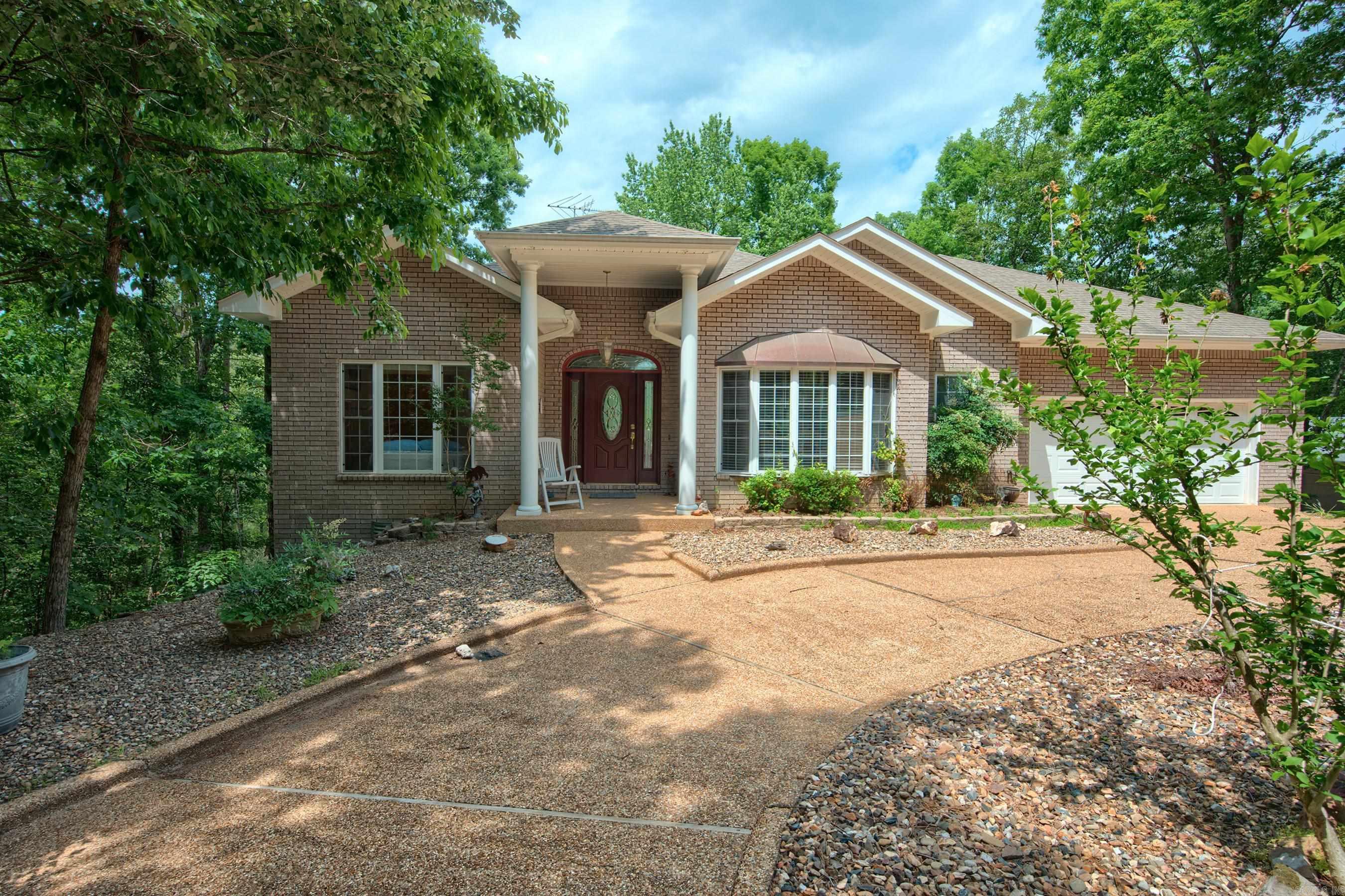 Discover the perfect blend of comfort, space, and opportunity at 44 Sur de Curso Way in beautiful Hot Springs Village. Surrounded by the natural beauty of the Ouachita Mountains, this inviting home features bright, open living spaces and a peaceful setting designed for easy Arkansas living. A circular driveway adds curb appeal and convenience with plenty of parking for guests and family. Basically there are two homes - a full 3/2 on the main level and a sunroom with outdoor deck.  Then downstairs, there's another bedroom and bath along with a kitchen bar area - perfect for another kitchen.  There are two large bonus rooms as well with a great outdoor covered deck.  Downstairs has both interior and exterior access for extended families or separate rental opportunities. Beautiful seasonal views of Cortez golf course and distant mountains.  Enjoy quick access to championship golf courses, scenic lakes, walking trails, restaurants, and all the amenities Hot Springs Village is known for. Whether you're relaxing at home or entertaining friends and family, this property offers the lifestyle buyers are looking for. Come make it your own!!