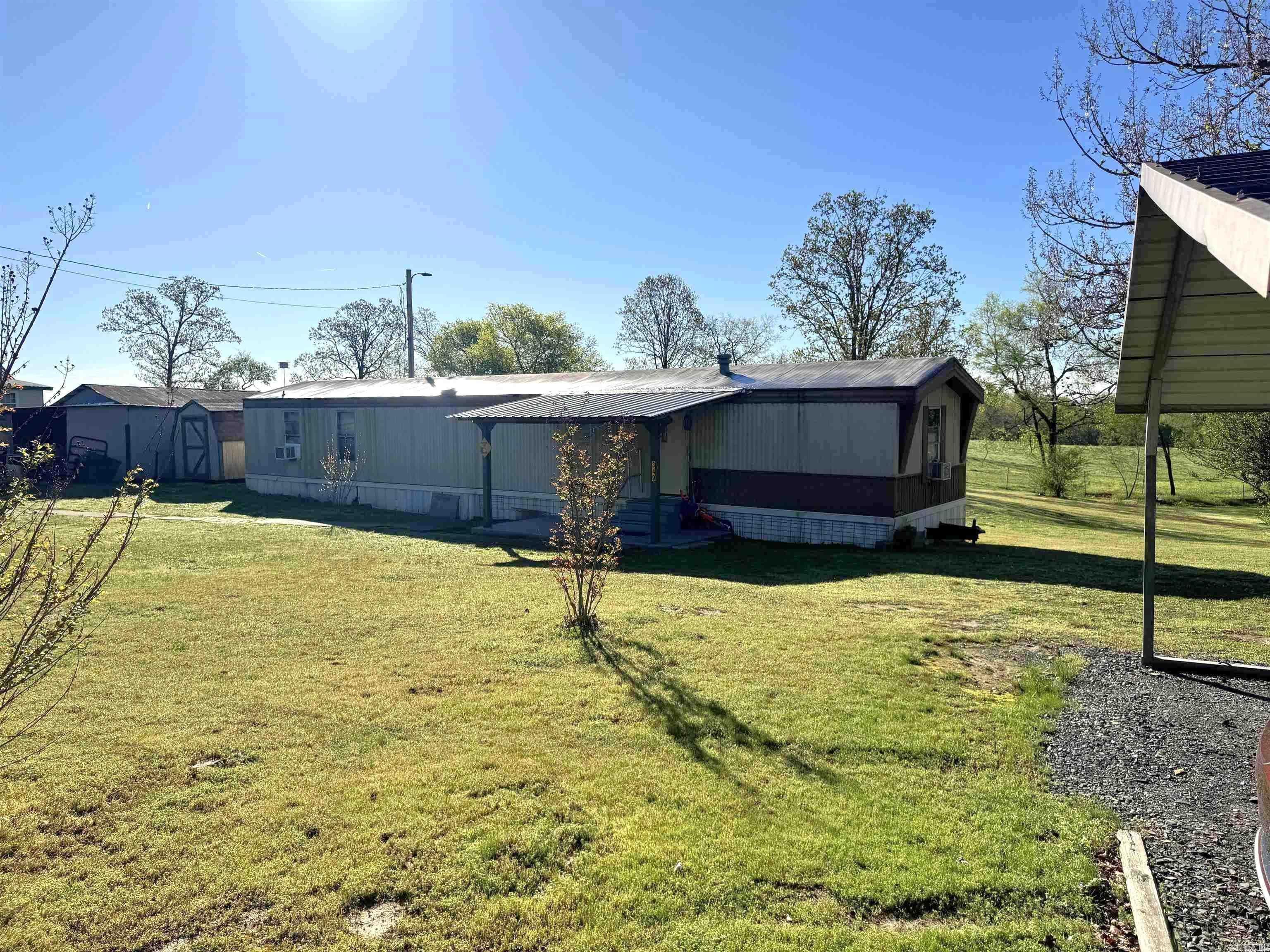 Set on 1.46 acres of peaceful, quiet countryside, this property offers the space and serenity you’ve been looking for. The mobile home provides a comfortable place to settle in, surrounded by open land that gives you room to breathe, relax, and enjoy the slower pace of country living.  Inside, the home is equipped with an electric hot water heater and electric stove, while propane is available on the property to serve as a backup heat source—giving you added efficiency and peace of mind.  In addition to the home, the property features a small outbuilding—perfect for storage, hobbies, or a workshop space.   The carport currently on the property will be removed prior to closing, creating an even more open and usable space for whatever you envision—whether that’s a garden, additional structures, or simply more room to enjoy the outdoors.  With plenty of space, added functionality, and a peaceful setting, this property is full of potential and ready for you to make it your own.