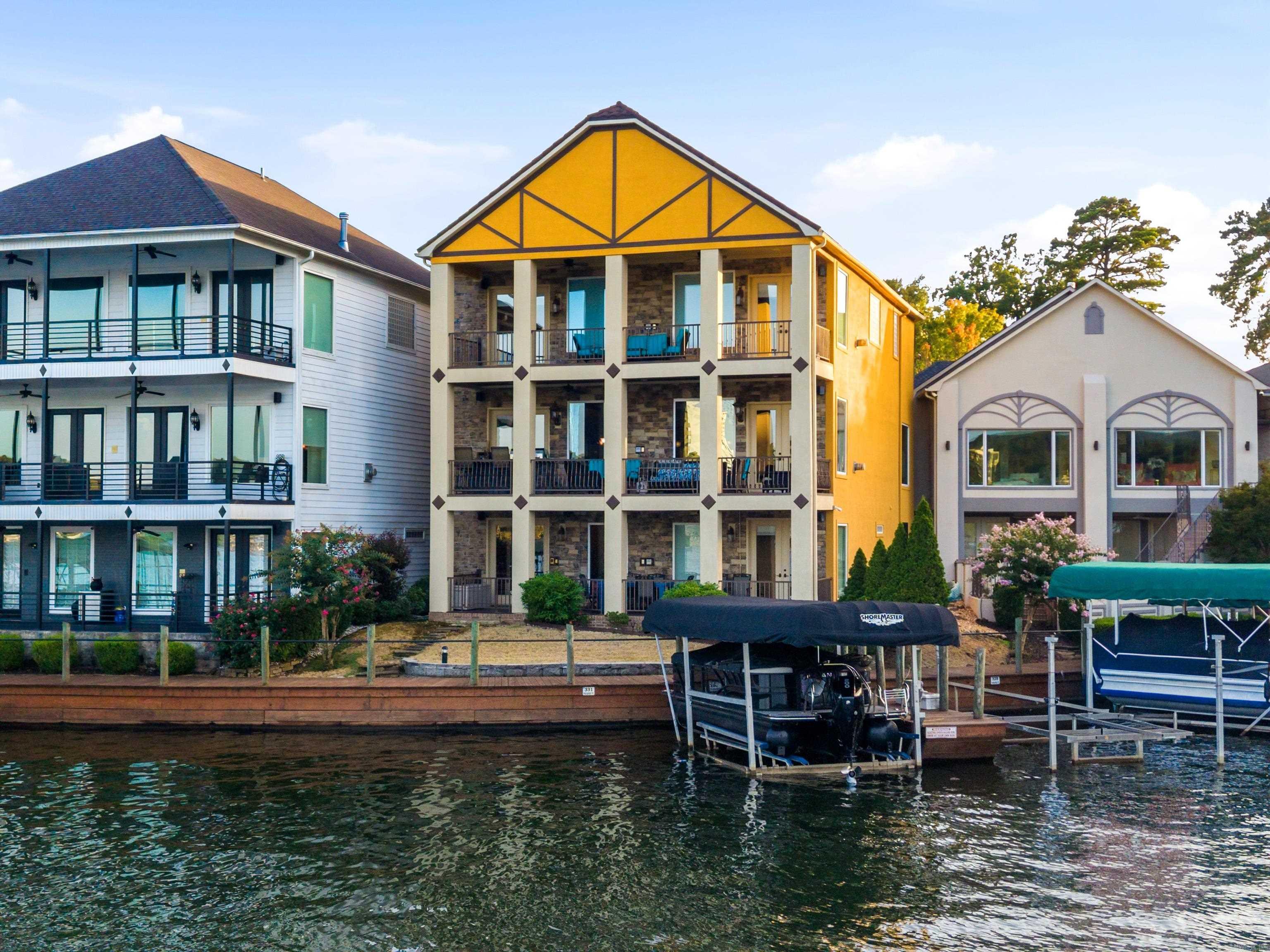 Lake Hamilton luxury living at it's finest awaits at beautiful Paradise Lake Village!  Main channel and vista views from each balcony of this gorgeous tri-level Tudor provides for a truly impeccable Hot Springs experience.  The walk in level boasts an expansive open floor plan with an incredible chef's kitchen including Viking and Subzero appliances, wet bar, and ample space for entertaining.  The upper level is your private primary ensuite including a fireplace and bathroom with an infinity jacuzzi and enormous custom shower for your own spa like experience.  Lower level includes another living area, wet bar, two bedrooms and two full baths.  Walk directly out to your boat slip, hop on the boat and enjoy all Lake Hamilton has to offer!  This home is being sold mostly furnished and even includes the boat making for instant summer fun.  Walk out the front door and enjoy the beautiful pool area complete with an outdoor kitchen and barbecue area.  No matter which direction you turn, you are surrounded by beauty that is unmatched.  What are you waiting for?  Schedule your showing today!