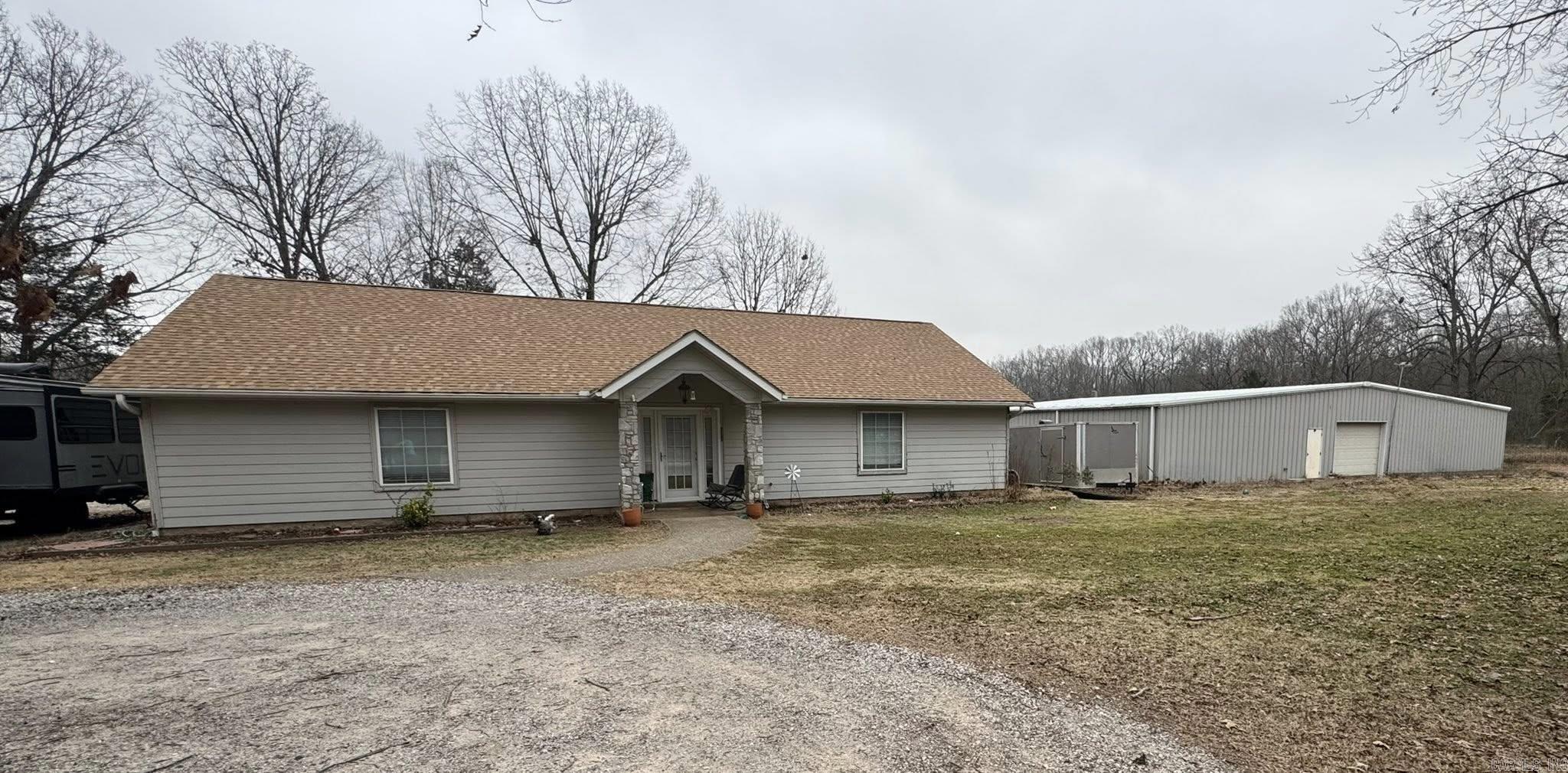 This well-maintained property offers comfort, space, and versatility on 1.19 acres, just minutes from town. The home features 3 bedrooms and 2.5 bathrooms, including two master suites, plus an additional bedroom—ideal for guests or flexible living arrangements. A large-covered patio and attached extra-large two-car garage add to the home’s everyday convenience. The property truly shines with two substantial heated and cooled shops, perfect for business use, hobbies, or storage. Shop One offers approximately 4,000 sq ft with office space, interior and exterior rooms, and an overhang for outdoor storage, heated and cooled with heated floors and plumbed to add a bathroom. Shop Two provides approximately 2,000 sq ft with a loading area that is heated. The home has been meticulously cared for and includes a new roof installed in 2024. Outdoor amenities include a spacious covered patio, RV parking pad with 50-amp service-water and electric, large playground area, and mature oak trees providing ample shade. Enjoy peaceful country living with the convenience of nearby town amenities—this property offers the perfect balance of privacy, functionality, and location