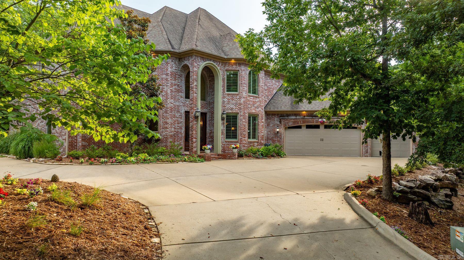 Tucked behind the gates of The Estates at McHenry Creek, this exceptional custom home offers 4,058 sq ft of refined living on 5 private wooded acres providing luxury living surrounded by serene nature. Soaring ceilings and an open-concept design create an inviting atmosphere, while the chef's kitchen features a massive granite island, new Frigidaire Professional appliances, and a large walk-in pantry. The main-level owner's suite offers direct pool access, dual walk-in closets—including a reinforced safe room—and a spa-inspired bath with jetted tub and separate shower. Upstairs features three bedrooms, two baths, and a spacious second living area with a private balcony. Resort-style outdoor living includes a heated saltwater pool with a cascading waterfall overlooking the wooded landscape, a 750 SF gazebo with built-in hot tub, a one-acre fenced yard, and a 1,500 SF raised flower garden with stone retaining wall. Updates incl full hardwood flooring, generator, fresh interior paint, new kitchen appliances, new pool equipment with a 450,000 BTU heater, and built-in garage cabinetry. A rare combination of privacy, luxury, and thoughtful improvements just minutes from West Little Rock.