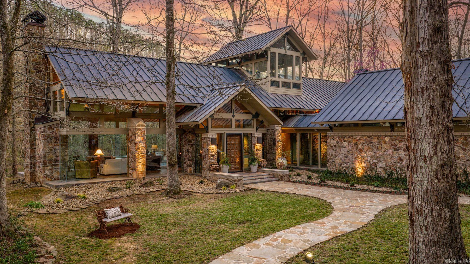 Tailwater Lodge is a premier riverfront retreat on the Little Red River just below Greers Ferry Dam. Secluded on 12.9 acres with 750+ feet of river frontage, the property offers exceptional privacy, with a conservation easement across the river ensuring protected, unobstructed views in perpetuity. Designed by Gene Levy of Cromwell Architects and custom built by Roberson Builders, the three-story residence showcases a striking blend of stone, wood and expansive glass. Floor-to-ceiling windows frame the picturesque surroundings at every turn, creating a seamless connection between architecture and nature. Beneath the all-copper roof, lies a vaulted great room with fireplace, multiple living spaces, bunk room and a crow’s nest with panoramic views—ideal as an office or fly-tying retreat. The primary suite offers dual baths, heated floors and a steam shower. Outdoor living is equally compelling, with multiple spaces positioned to capture long river views. A covered dock with two boat slips provides immediate access to one of the nation’s premier year-round trout fisheries. Located near Greers Ferry Lake, the property offers both river and lake living in a private, natural setting.