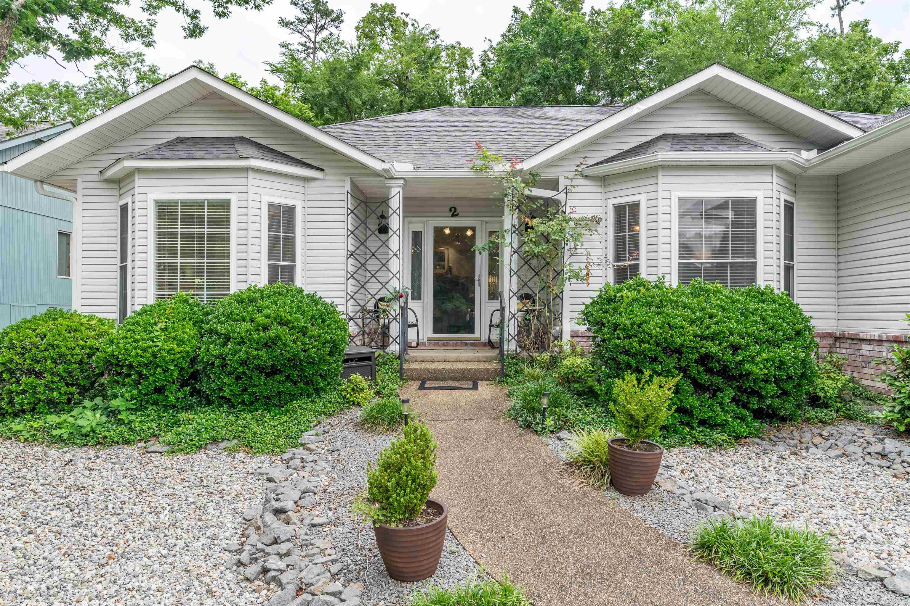 Located in the heart of Hot Springs Village, this property is less than five minutes from Coronado Lake, Coronado Fitness Center and tennis facility. Sitting on a spacious corner setting, the sale also includes the two adjoining lots to the right of the home, creating extra privacy, additional space, and future possibilities that are hard to find this close to the center of the Village.  Inside, the home has a comfortable and inviting feel with abundant natural light, and a layout designed for easy everyday living. The living room centers around a wood-burning fireplace, while the kitchen features granite slab countertops, a breakfast bar and functional flow into the dining area. Large windows throughout the home give each space an open feel and bring in the surrounding greenery.  The backyard and patio area offer a quiet place to relax, entertain, or simply enjoy the extra elbow room provided by the additional lots. With all three bedrooms on one level, a two-car garage, and a level corner lot in a highly convenient location, this property combines comfort, space, and access to Village living! SEE AGENT REMARKS