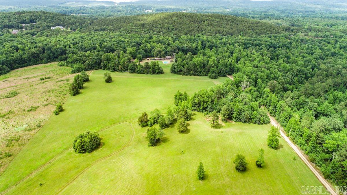 Gorgeous level land with pasture and woods. Kinley Creek flows across the back section. Cozy 550 sq ft cedar cabin with a loft bedroom, screened in porch, fireplace, kitchen, and living room. Well and Septic are already in place.  There is an  in-ground pool. Barn/shop with pit for changing oil, overhangs for hay and tractor storage. Public water is available.  No restrictions. Agents see remarks.
