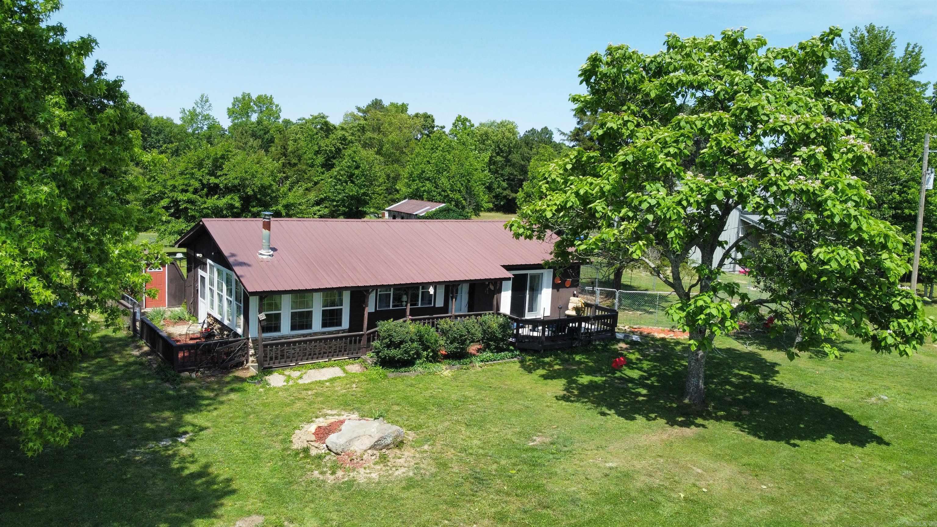 Welcome to the market this gem of a property. 40 beautiful acres and a well maintained 2 bedroom, 2 bathroom home with a deck on front and back, all electric with central heat and air, a small wood burning stove, back-up propane heaters, a fifth-wheel camper that sleeps six, all set up for visitors with it's own water, electric and septic system. A 50 x 40 shop to store all of your tools and toys in, with a 10 ft overhang to park equipment and more toys under. There is a spring fed pond that is stocked with fish for your enjoyment. There are several outbuildings that include a 4 stall horse barn, 2 hog houses, and another building that could be a chicken coop. There is a storm shelter. The grass on the property has been cut for hay each year and there are also mature trees scattered about the property. This is ready for you, your family and all of your animals! Make this your very own homestead.