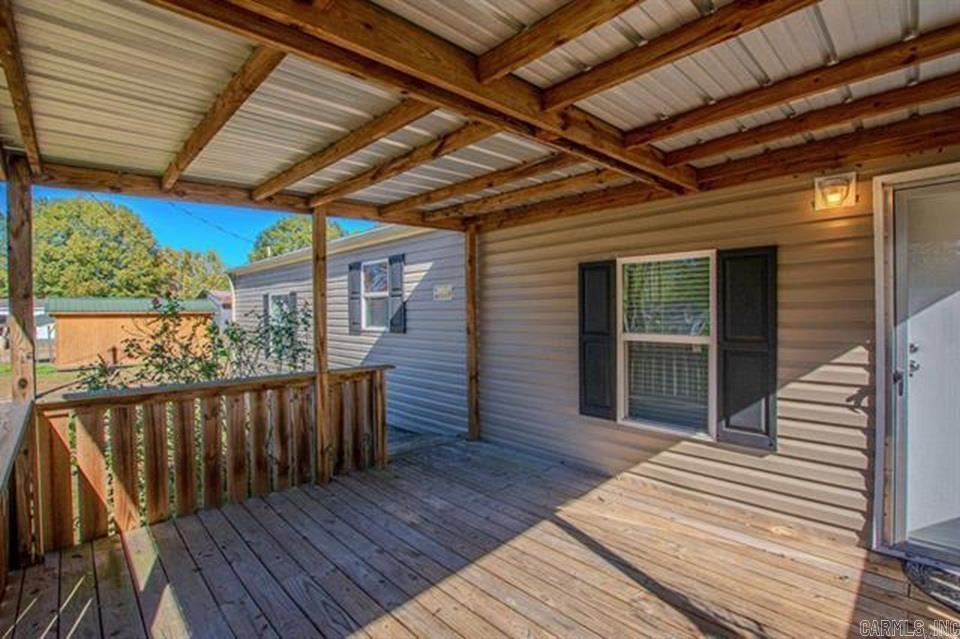 Welcome to this charming and quaint single wide mobile home sitting ever so perfectly on almost an acre of property. In excellent condition in every aspect. Maintenance free vinyl exterior siding along with gutters all around with covers. Central HVAC, nice vinyl windows, 2 split-plan spacious bedrooms, 2 full bathrooms, kitchen counter breakfast bar, Gas stove, refrigerator and dryer stay, large living room, dining area, and separate laundry space. Nothing to do on this great space but just move in and enjoy. There are 2 covered decks, one in the front, and one in the back. The view of the backyard is beautiful and serene. Almost an acre of cleared property, fully fenced all around, outside storage building with a lean-to, mature Pecan trees, shrubbery, roses, flowers, and ample space for the avid gardener. Slightly graveled driveway for plenty of parking. The front yard is completely fenced in as well with a driveway gate. Don't miss the opportunity to see this perfect little place and make it your own. Financing options are available. Please see Agent Remarks.
