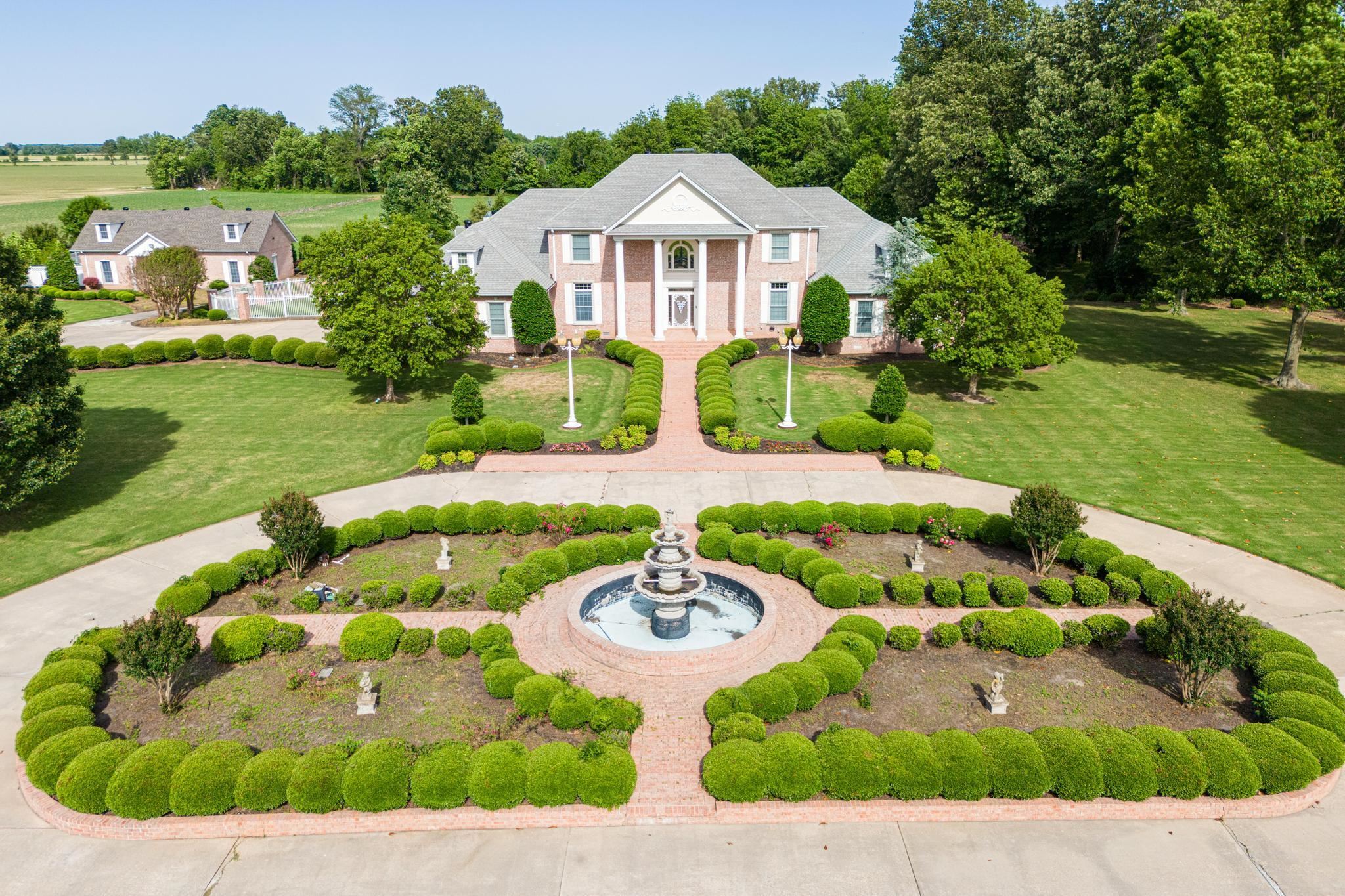 Welcome to your private sanctuary on nearly 16 acres of manicured land. This impressive 4-bedroom, 5 full and 2 half-bath estate offers spacious living with some fresh paint and thoughtful details throughout. Enter through the gated iron and brick entry to lush landscaping and a beautiful fountain. Inside, the chef’s kitchen features granite countertops, high-end appliances, and a gas range with built-in griddle, opening to a large dining area, breakfast nook, and sunroom filled with natural light and backyard views. The primary suite is a true retreat with a vaulted sunroom, cozy gas fireplace, double closets, and relaxing en-suite bath. Each bedroom has its own bath for family or guests. A roomy office or den adds flexibility. Outside, enjoy a large deck, gazebo, and landscaped gardens perfect for dining or relaxing. A spacious shop with a three-car garage adds extra space for hobbies or work. Peaceful and private, yet convenient to the 412 Bypass!