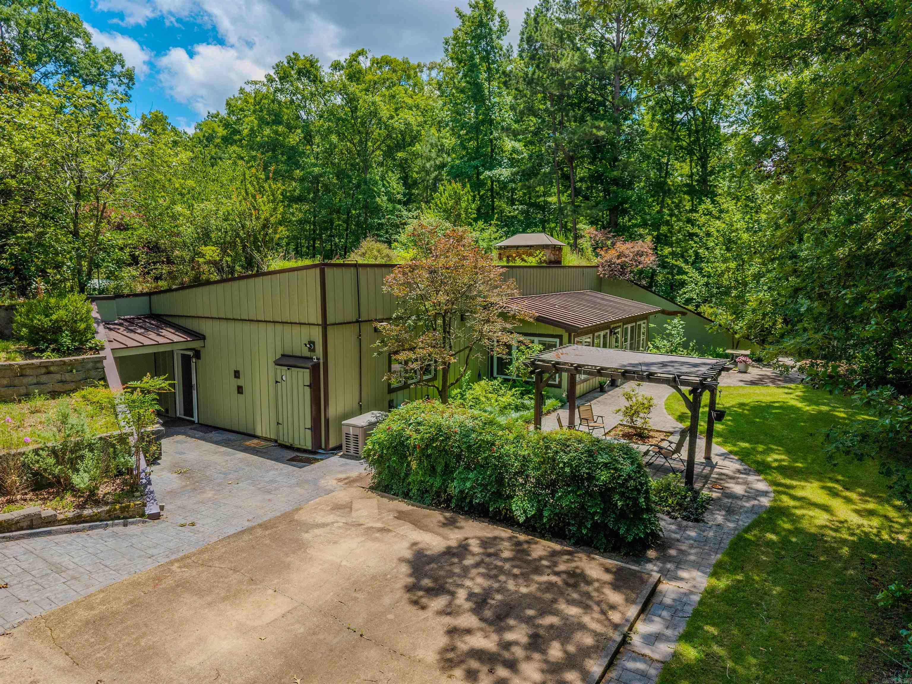 HERE'S A RARE OPPORTUNITY TO OWN A TRULY VISIONARY HOME DECADES AHEAD OF ITS TIME.  A CUSTOM EARTH-SHELTERED RESIDENCE, WITH ITS THE ORIGINAL OWNERS, COMBINES DURABILITY, ENERGY EFFICIENCY & TIMELESS DESIGN. ON 5 BEAUTIFUL ACRES IN SALINE COUNTY, THE HOME WAS CONSTRUCTED OF CONCRETE & STEEL.  THE ROOF CONSISTS OF A 12-INCH REINFORCED CONCRETE SLAB COVERED BY AN AVG OF 3 FT OF SOIL, PROVIDING EXCEPTIONAL INSULATION.  DESIGNED AS AN ALL-ELECTRIC HOME, IT ALSO INCLUDES A PROPANE-POWERED GENERAC BACKUP GENERATOR FOR PEACE OF MIND.  A BUCK WOOD-BURNING STOVE EFFICIENTLY HEATS THE ENTIRE HOME & THE ORIGINAL SOLAR HOT WATER PANELS CONTINUE TO REFLECT THE HOME'S INNOVATIVE SPIRIT. THE HOME HAS BEEN CAREFULLY RENOVATED AND UPDATED WHILE PRESERVING ITS UNIQUE ARCHITECTURAL CHARACTER.  RECENT IMPROVEMENTS:  PARTIAL WATERPROOFING, DRAINING ENHANCEMENTS & NEW SIDING. ADDITIONAL FEATURES: ESTABLISHED GARDEN AREA, COVERED PARKING STRUCTURE FOR RV'S AND TRACTORS (WHICH INCLUDES A LOOP DRIVEWAY) SHOP BUILDING WITH VEHICLE STORAGE POTENTIAL AND AN ADDITIONAL STORAGE BUILDING. IF YOU'RE LOOKING FOR A DISTINCTIVE HOME BUILT TO STAND THE TEST OF TIME, THIS REMARKABLE EARTH-SHELTERED HOME IS A RARE FIND