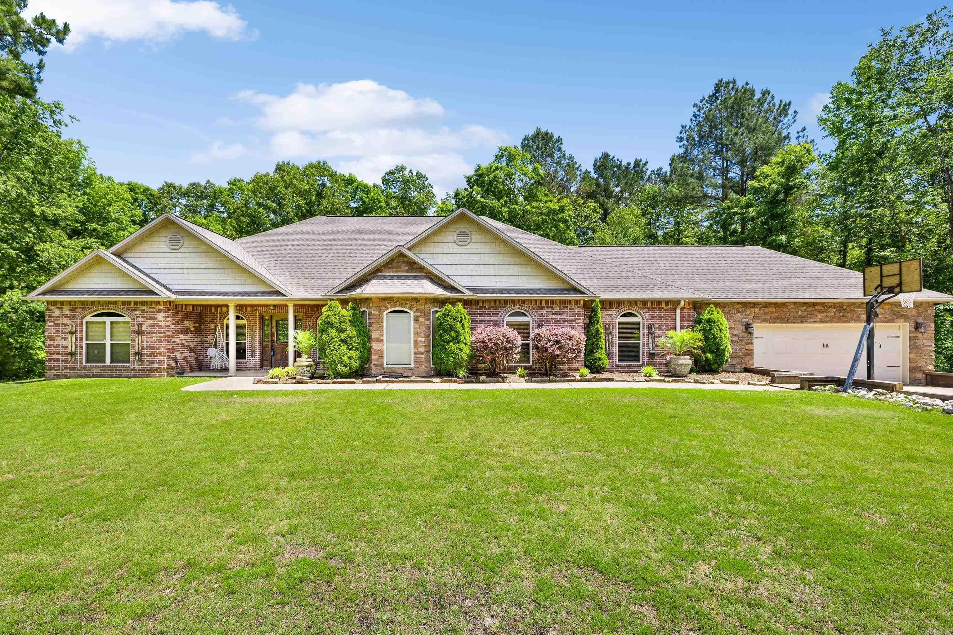 Beautiful Home on 3.44 acre Corner Lot in Sought-After River Ranch! Enjoy the best of country living just minutes from I-30 and downtown Benton in this stunning home located in the desirable River Ranch Phase III subdivision. This spacious residence features 4 large bedrooms, including a luxurious primary suite with oversized closets and a spa-like bathroom. Step into a grand foyer that opens to a generous living area highlighted by a rock-accented fireplace. The kitchen is a chef’s dream—perfect for cooking and entertaining. Two additional flex rooms offer space for a formal dining area, den, or playroom. Additional highlights include a built-in safe room, mudroom, oversized two-car garage, and a screened-in back patio overlooking a large, private backyard with wooded surroundings. This home is filled with features that must be seen in person to be fully appreciated