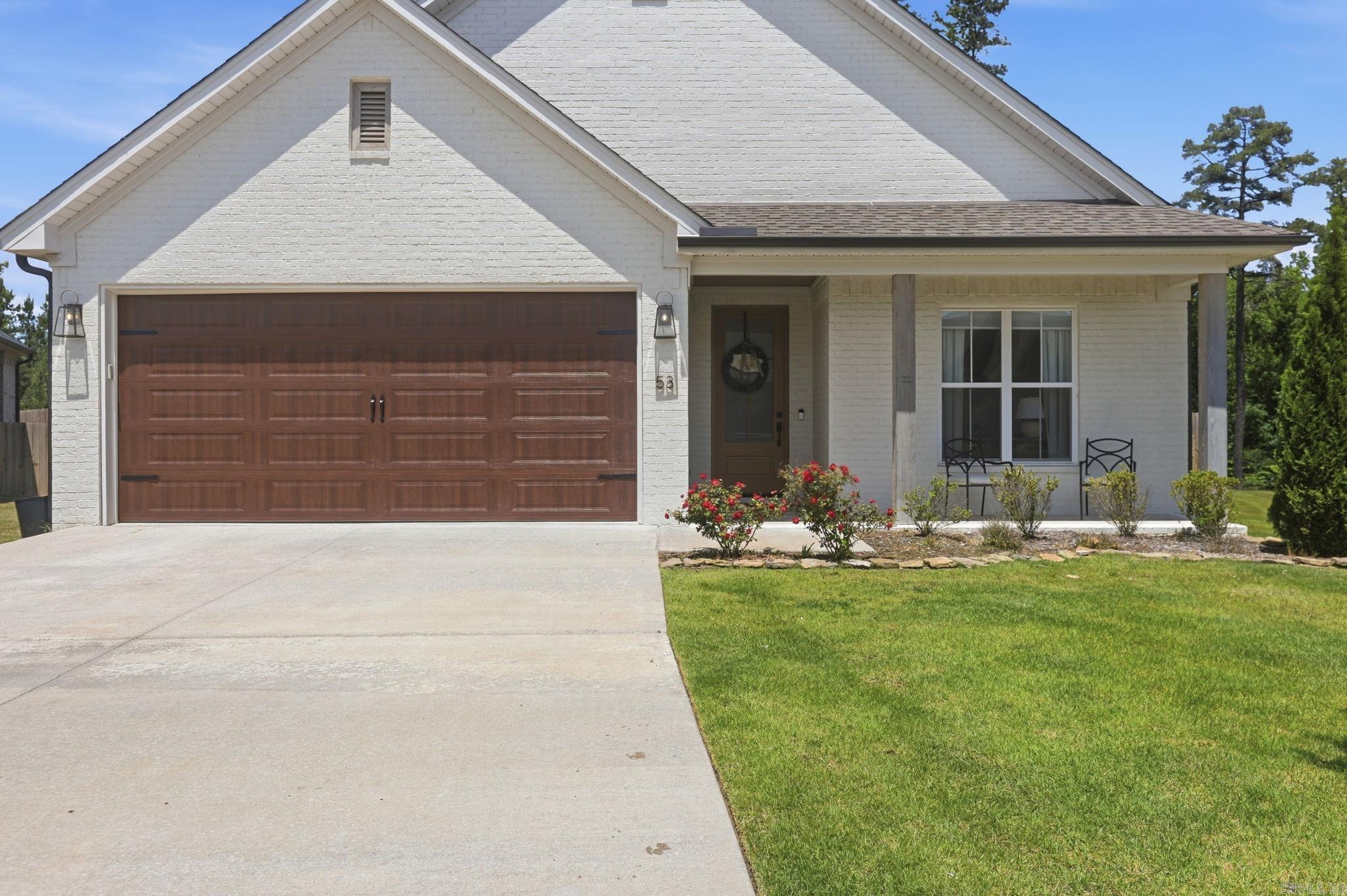 Surrounded by lush landscaping and mature trees, this home sits on a corner lot with a massive backyard. Notably, landscaping services are included in the annual dues. This single-level home features three bedrooms and two full bathrooms with a functional, stylish layout. The primary suite serves as a sanctuary, featuring a soaking tub, an oversized walk-in shower, and an expansive custom closet.  Designer-curated finishes and superior craftsmanship are evident throughout the property. The open-concept design is perfect for entertaining and includes a chef’s kitchen with quartz countertops and custom cabinetry. Additionally, the home offers a large, covered patio for outdoor living.