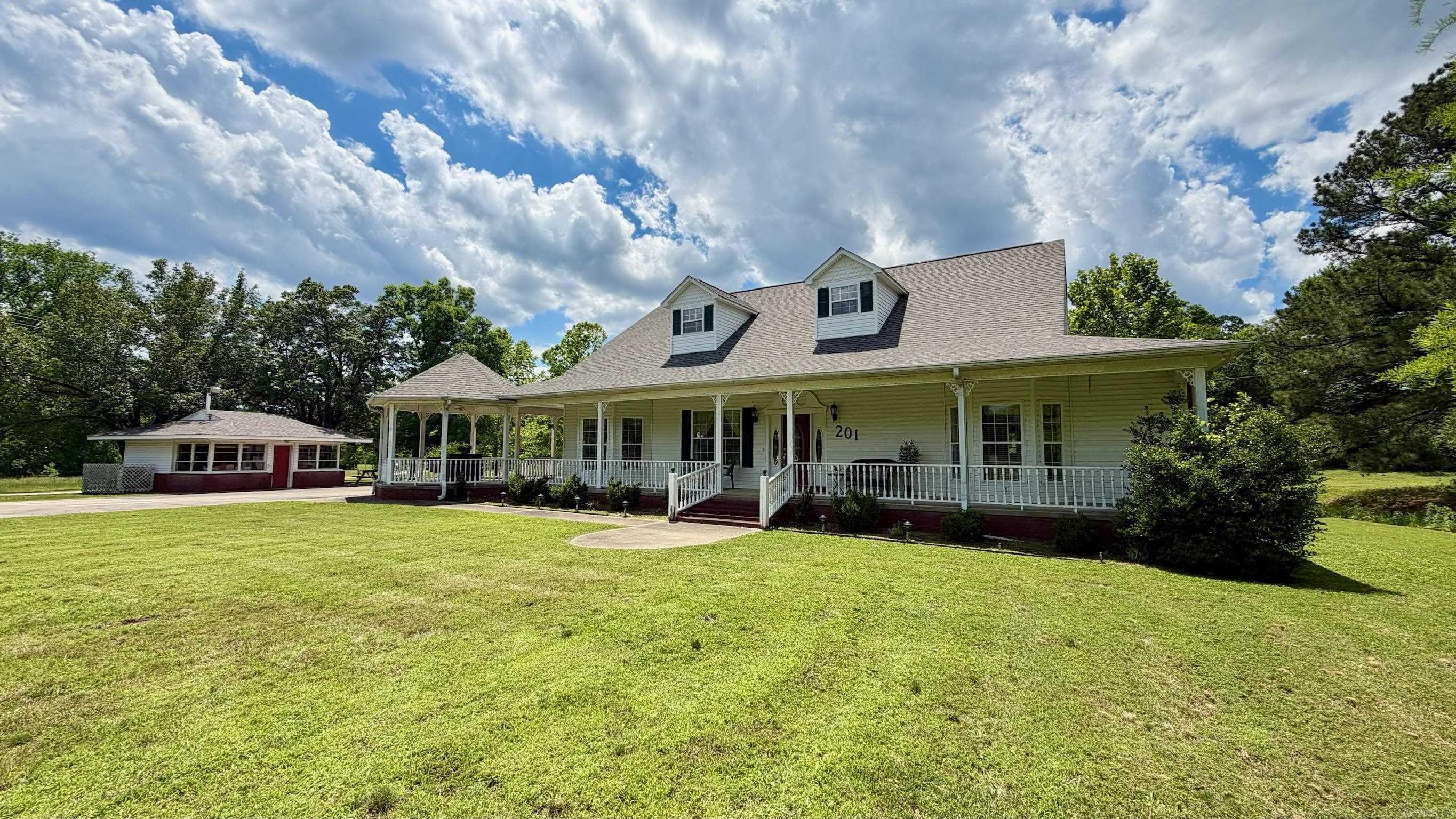 Welcome to 201 Green Willow Lane, a spacious two-story home on 1.6 acres accessed by a private driveway with lovely views of the surrounding property. Offering 3,506 SF with 3 bedrooms and 4 bathrooms, this home delivers the space, privacy, and comfort of true country living. The living room features an elegant tray ceiling and a gas log fireplace, creating a warm and inviting gathering space. The kitchen is equipped with granite countertops, and a thoughtful mix of hardwood, carpet, and tile flooring flows throughout the home, adding character to every room. Abundant storage throughout ensures there is a place for everything. A wraparound covered porch spans the front and side of the home, while a second covered porch on the rear provides even more outdoor living space to take in the views and enjoy the surroundings year-round. A detached workshop adds real versatility for woodworking, hobbies, or organized storage. Situated on a peaceful 1.6-acre lot with convenient access to dining, shopping, Lake Hamilton, Oaklawn, Garvan Gardens, and all that Hot Springs has to offer. Agents, see remarks.