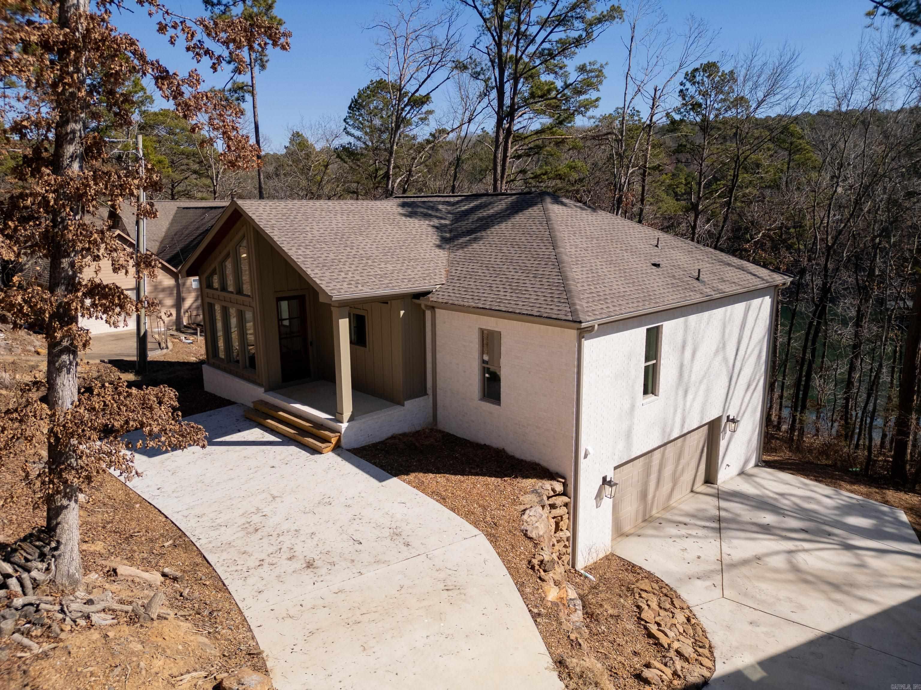BOAT SLIP on GREERS FERRY LAKE!!!  Enjoy the perfect blend of luxury, comfort, and lakeside living in this stunning five-bedroom, three-bath home. Featuring a beautiful all-brick exterior, this thoughtfully designed property offers multiple outdoor living spaces ideal for relaxing or entertaining while taking in the serene surroundings. Inside, you’ll find vaulted ceilings, two spacious living areas, and exceptional craftsmanship that is evident in every detail. Additional highlights include a two-car garage and a dedicated safe room for added peace of mind. With quality construction throughout and direct lake access with your own boat slip, this beautiful home is truly a must-see!