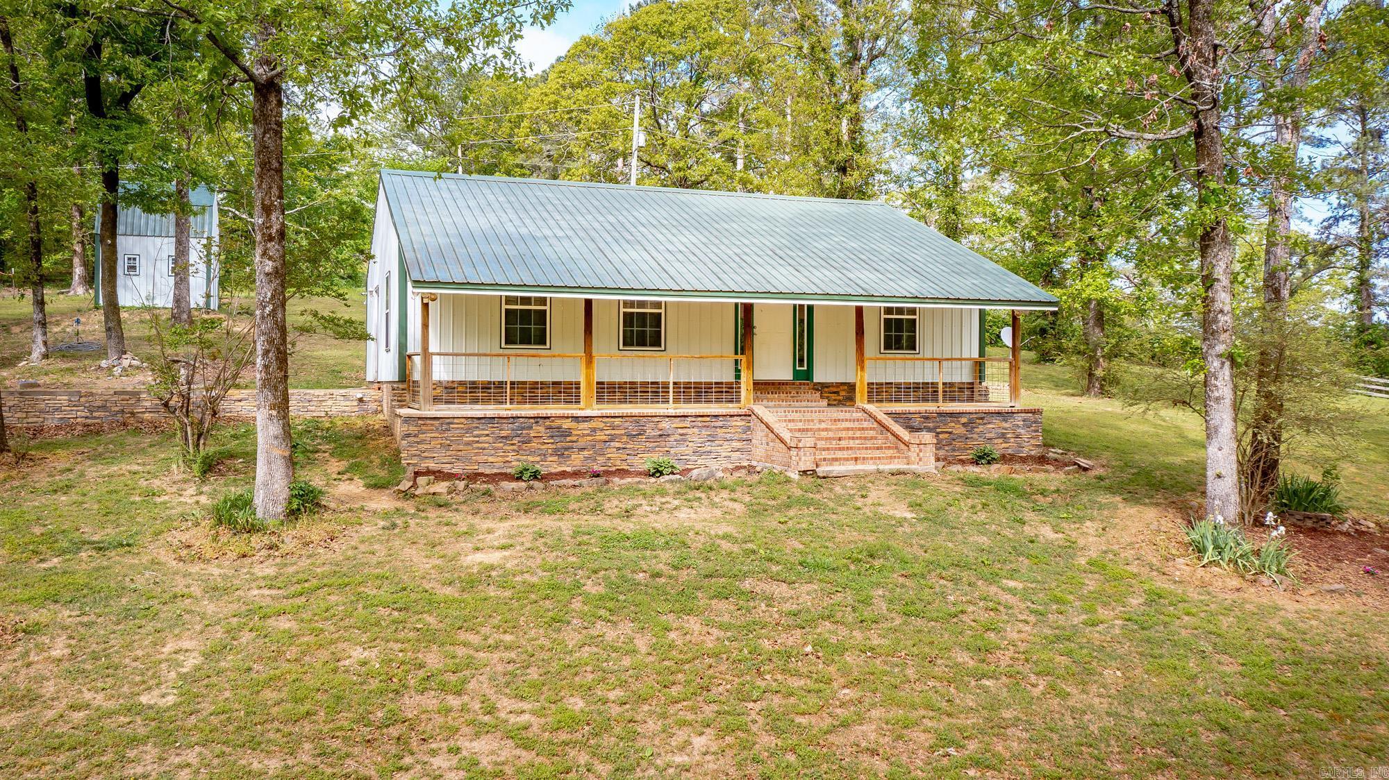 Charming 2 bed, 2 bath home on 2.2 beautiful acres with the perfect mix of space and functionality! Inside, you’ll love the oversized living room featuring stunning custom wood walls and a warm, inviting feel. The open kitchen offers an abundance of custom wood cabinetry, tons of pantry storage, a breakfast bar, and a spacious dining area—perfect for everyday living or entertaining. The primary suite includes a custom tile shower and direct access to the outdoors, adding a private retreat feel. Outside, the property is set up for country living with a workshop with electricity, a fenced area ready for horses, and plenty of room to roam. Bonus: a slab has already been poured with plumbing in place, making it easy to add a new primary suite or expand the home. Don’t miss this one!