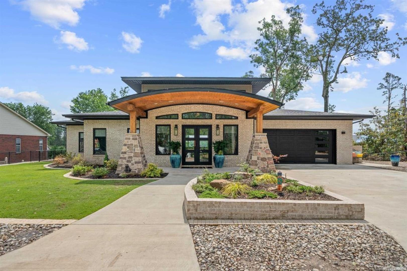 “Stunning Contemporary Home with Lake View and Covered Boat Slip” This modern gem is nestled close to town, offering convenience and tranquility. As you approach the property, you’ll be captivated by its sleek lines, large windows, and minimalist design. The home boasts clean lines, open spaces, and a harmonious blend of natural materials such as wood, glass, and steel. Floor-to-ceiling windows allow abundant natural light to flood the interior, creating a seamless connection between indoors and outdoors.  Imagine waking up to panoramic views of the serene lake every morning. Whether you’re sipping coffee in the kitchen or relaxing in the living room, the water’s shimmering surface will be your backdrop. The spacious deck or patio provides the perfect spot for alfresco dining, sunsets, and stargazing.  Pet friendly home with dog washing center, fenced yard and dog doors.  Whole house generator, primary suite with huge walk-in closet plus an additional closet for tons of storage.  Large pantry off kitchen, views of the lake from front and rear of this stunning masterpiece!  Awesome patio in the back yard with fire pit overlooking Lake Hamilton and Garvan Gardens.