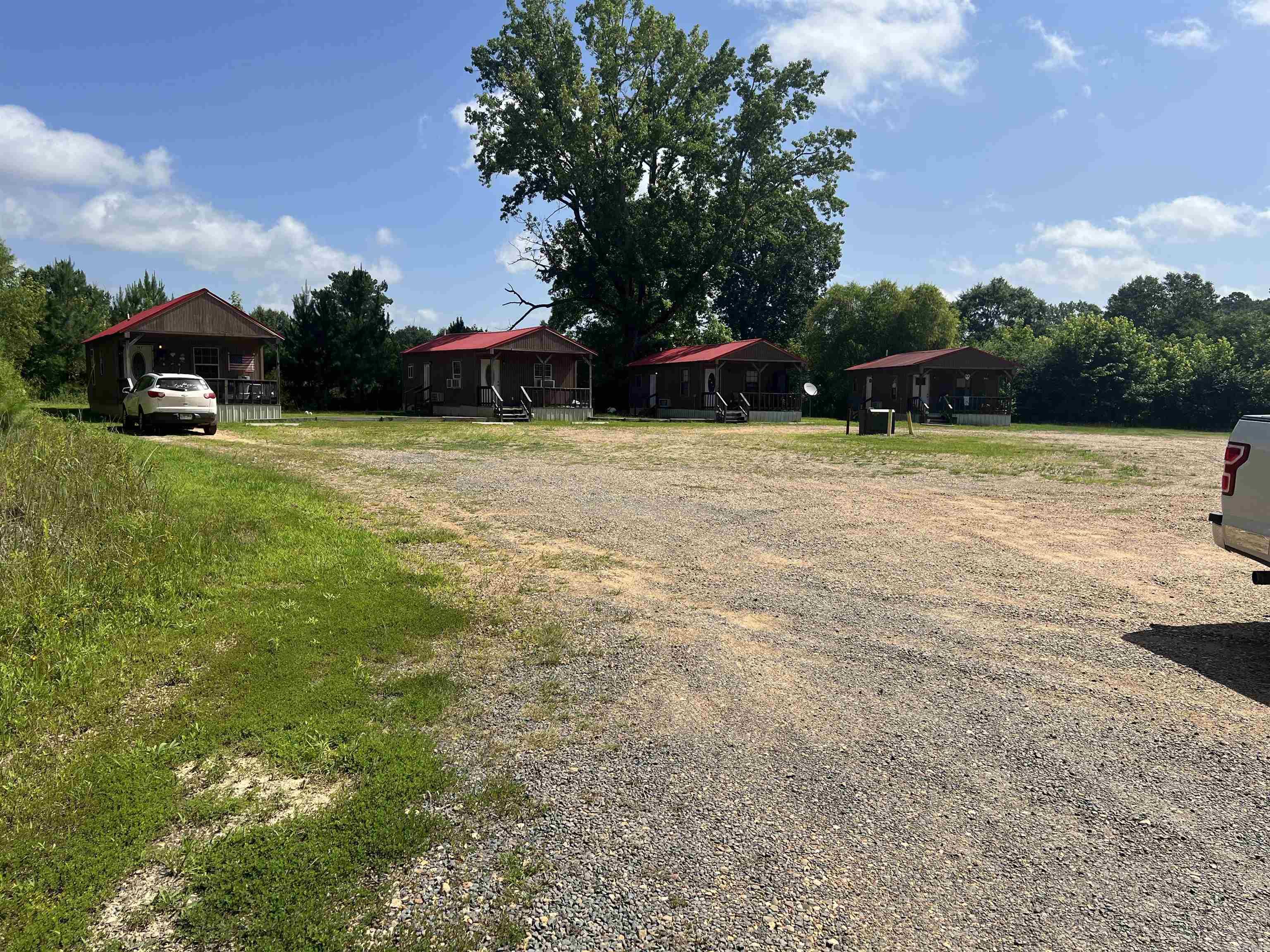 Exceptional 55 acres+/- Investment & Development Opportunity !! Rare opportunity to Own approx. 55 acres in a prime location directly across from Walmart with high traffic exposure in DeQueen Arkansas. Approx 13 acres are commercially zoned, offering outstanding possibilities for retail, hospitality, RV Park, or future development. Commercial portion includes 13 income-producing rental cabins, all currently occupied, along with two homes and one mobile home on the property that is tenant-owned.These properties have city sewer and water, all electric.  One large shop ,one pole shed. Remaining property is pastureland with cattle grazing.