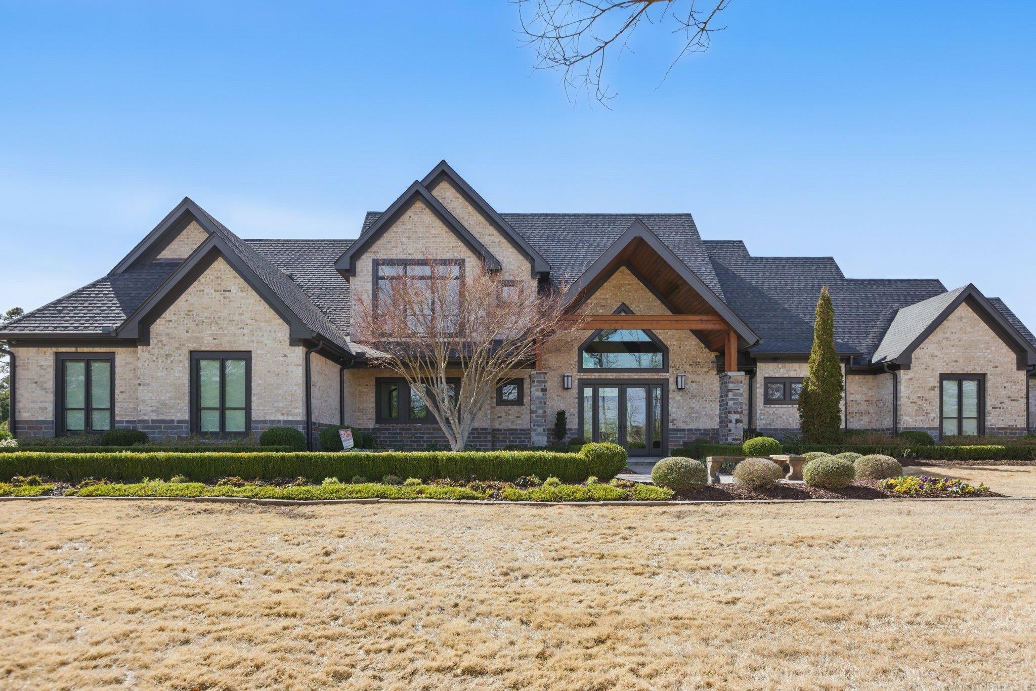 Step inside this one-of-a-kind masterpiece. As you enter, you'll be greeted by a stunning view of the pool, overlooking the wooded terrain and Lake Maumelle. The open foyer welcomes you with a vaulted, jagged wood ceiling and a custom-designed staircase with glass walls.  Kitchen has Thermador appliances, a double oven, a Sub-Zero fridge/freezer unit, a crushed ice machine, quartz counters, a walk-in pantry, and a glassed wine room w/ a wine fridge and wet bar. Enjoy two main living areas: one perfect for cocktails overlooking the pool & lake, and a cozy den with a fireplace for relaxing w/ a book.  Tile flooring extends throughout the home, and all windows are tinted for UVA sun protection and equipped with Hunter Douglas electric shades with personalized automation. Additional features include a water filtration system, dehumidifying HVACs w/ multi-zone controls, tankless gas water heaters with continuous hot water flow, a Generac generator, and a tornado-safe roof.  Step outside to a private setting with estate landscaping, a pool and spa, an outdoor kitchen, an automated mosquito misting system, speakers, and cameras.