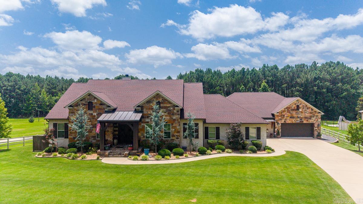 Nestled on nearly two private acres this one-of-a-kind estate blends true craftsmanship with exceptional amenities.  Stunning brick archway entry, great room with beamed ceilings and native stone fireplace.  The spacious eat-in kitchen serves as the heart of the home featuring custom hand-crafted solid wood cabinetry, granite countertops, hammered copper farm sink, double ovens, breakfast bar and walk-in pantry. The main level of the home includes the primary bedroom and spa-like bath along with three additional bedrooms. This home is perfect for in-laws or teens. Several bedrooms overlook the pool.  There's a second living space with a kitchenette. The oversized game/exercise room has built-in sound.  Upstairs are two bedrooms, bath and playroom with built-ins. The exterior has an iron security gate, garage parking for 5 vehicles, bike/sporting equipment storage (not included in sf), separate shop/garage, 40' long inground pool. Cedar pavilion w/metal roof, tongue and groove ceiling, wood burning fireplace, double-sided wood box, ceiling fan, mini-fridge and authentic pizza oven. Craftsmanship, privacy and natural beauty come together in perfect harmony here.