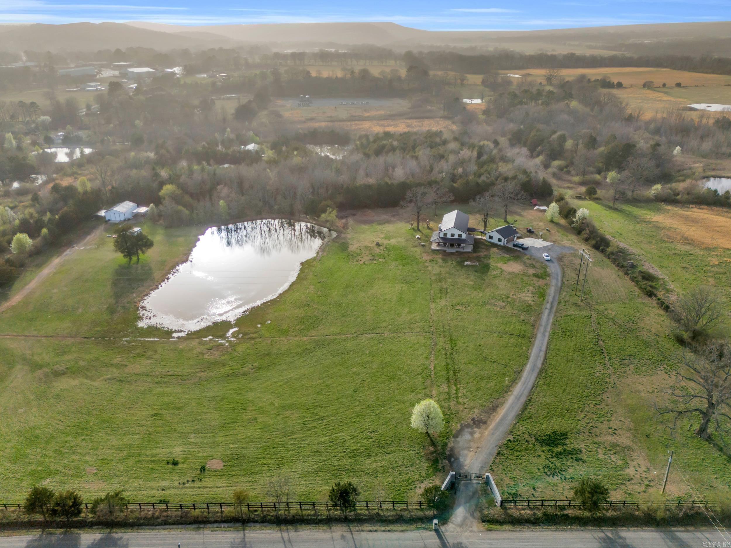 Welcome to this stunning 2-story home, built in 2022 and perfectly situated on +/- 5.22 acres of peaceful countryside. With a spacious wrap-around porch, 2-car detached garage, and a list of incredible features, this property truly has it all! Inside you'll find 4 bedrooms, 2.5 bathrooms, and an open-concept living space that's made for entertaining. The gourmet kitchen includes a walk-in pantry, high-end appliances, quartz-countertops, and custom cabinetry, while the oversized laundry room offer not one, but two washer/dryer sets. There's even a dedicated mud room and dog washroom to keep things clean and organized! Upstairs, the luxurious primary suite is a true retreat, featuring his and her vanities and closets, a soaking tub, loft area, and a cozy gas fireplace right in the bedroom. Outside, you'll find a hot tub, storm cellar, RV hook-ups, & breath-taking scenery. This property is outside of city limits, so bring your cows, horses, and chickens! Very close to public River access. 15-20 minutes to Searcy or Heber Springs. This home with acreage is available for purchase, with additional options to buy the pond and acreage or the shop and acreage separately. See agent remarks!